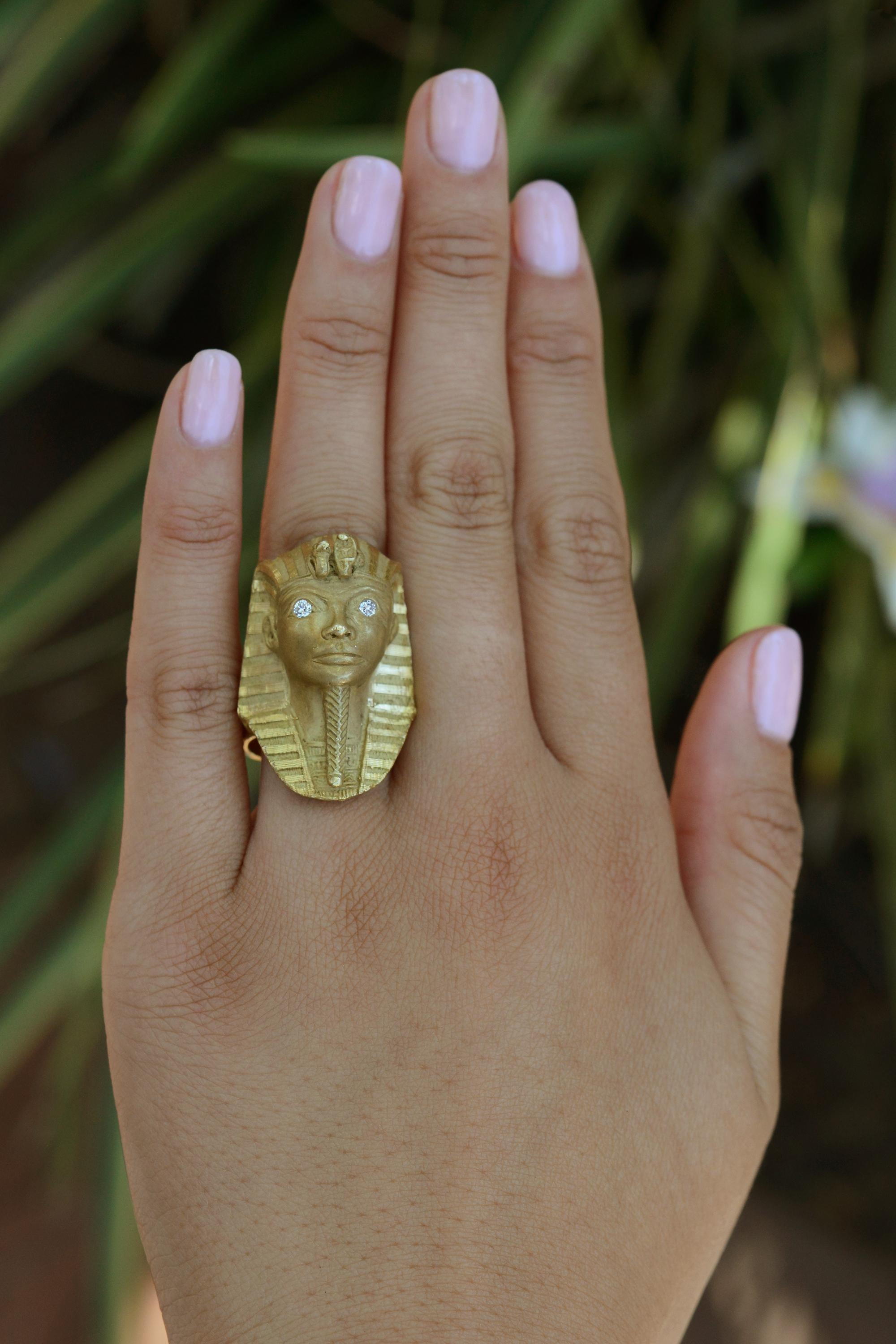 An eye-catching tribute to antiquity, this weighty 18 karat yellow gold King Tut ring is an Egyptian revival treasure. Diamond eye inlays sparkle with timeless beauty, whilst the famed pharaohs crown glints with phenomenal bespoke workmanship. A