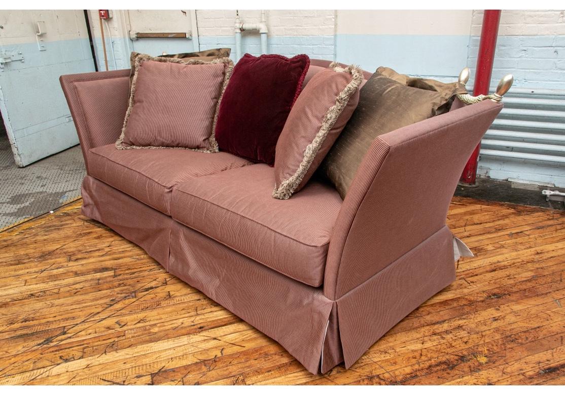 The iconic Knowle House style sofa with, in this case, fixed drop-down sides, interpreted by Fine furniture creators and upholstery firm Henredon. In exceptional condition and featuring dense comfortable cushions, silver top finials and five