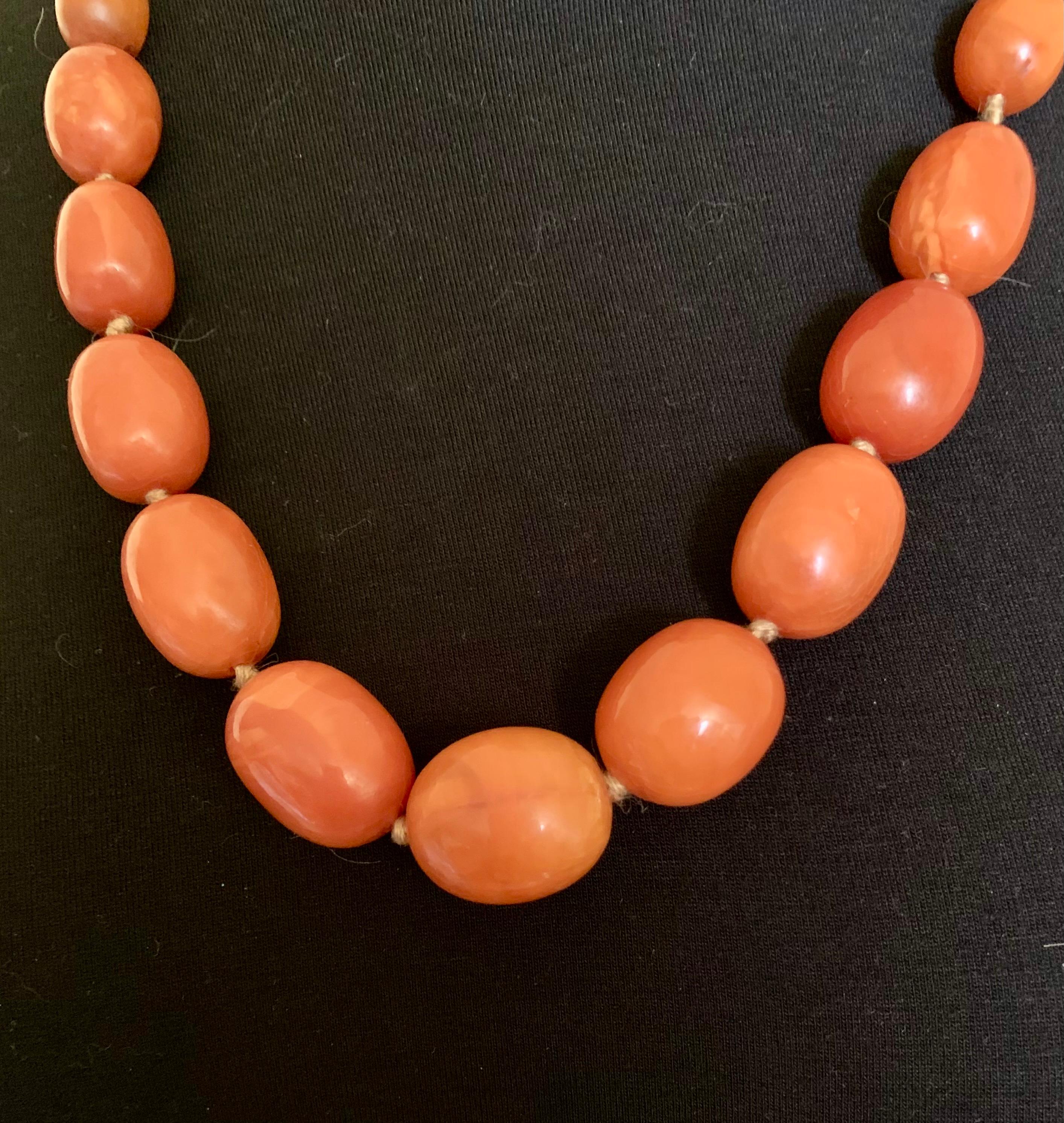 Beautiful, large, natural graduated oval bead antique amber necklace composed of thirty four hand knotted beads 25mm to 6mm, of desirable yellow-orange color with attractive natural variegation.
19th Century
Length: 26 inches
Amber is fossilized