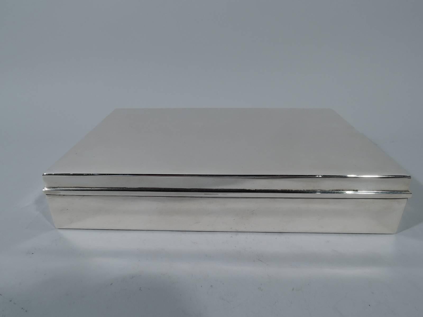 Large and classic sterling silver box. Made by Tiffany & Co. in New York. Rectangular with straight sides. Cover flat and hinged with molded rim. Box interior cedar lined and partitioned. Postwar hallmark includes pattern no. 22358. Gross weight: 32