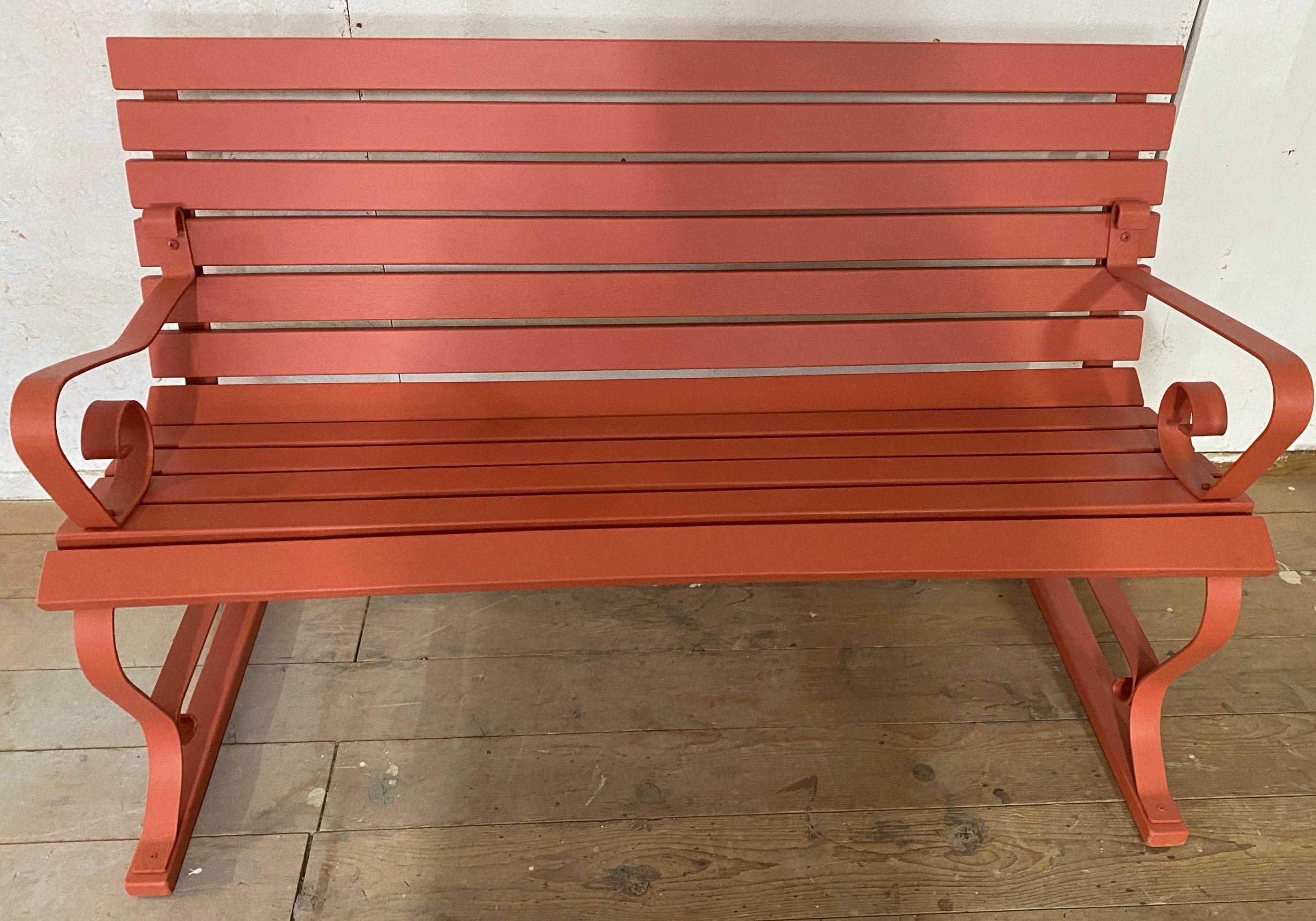 A simple, classic late 19th century, slat design wrought iron park / garden bench with wood slat seat and back. The iron metal frame has curved arms and legs. The two arm supports are NOT identical. Newly painted. Ask us about painting it in a