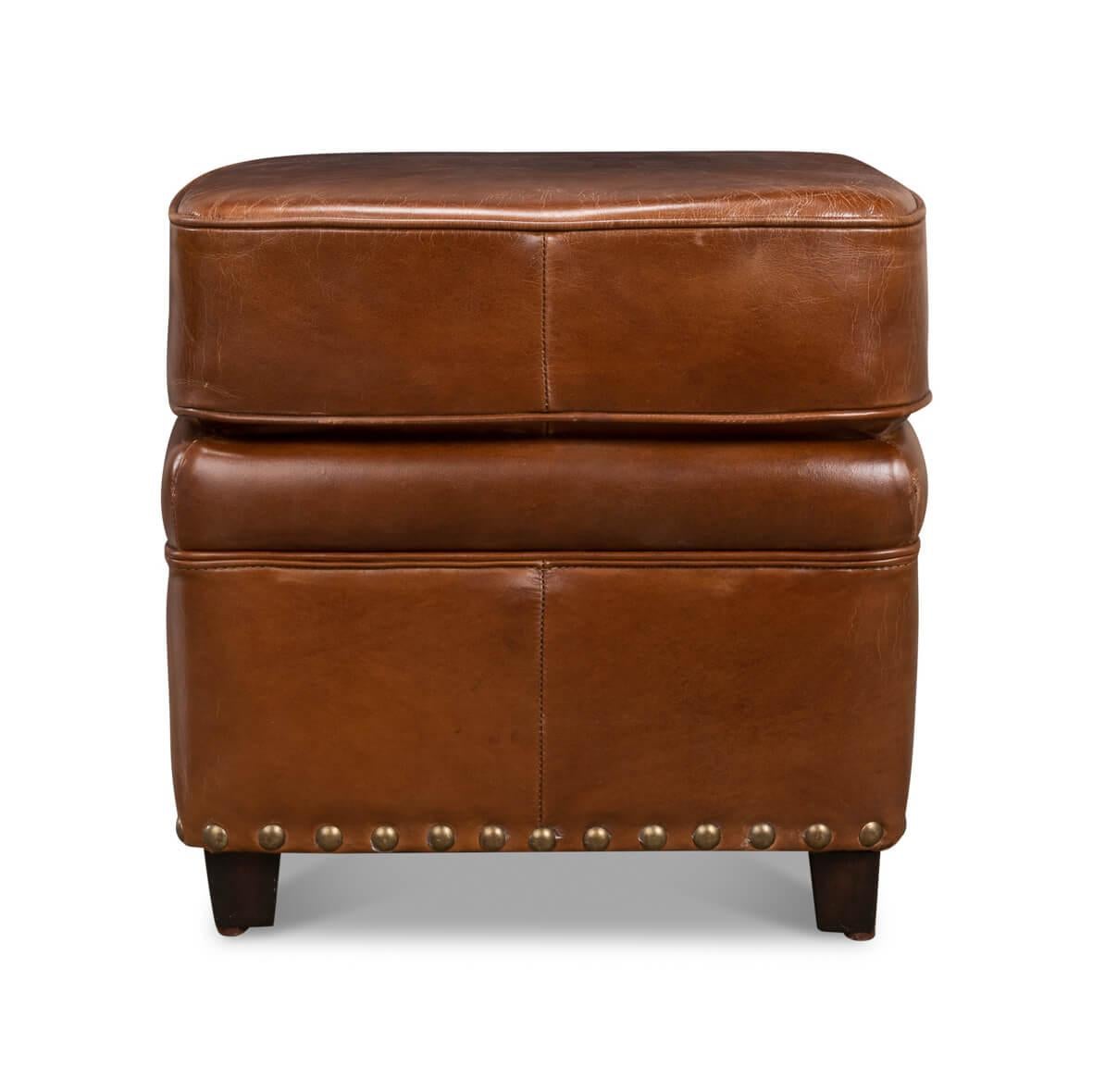 A blend of timeless design and comfort! Wrapped in a rich, caramel-hued top-grain leather, this ottoman exudes an air of classic sophistication.

Accentuated with oversized antique brass nailhead trim, the ottoman brings a dash of old-world elegance
