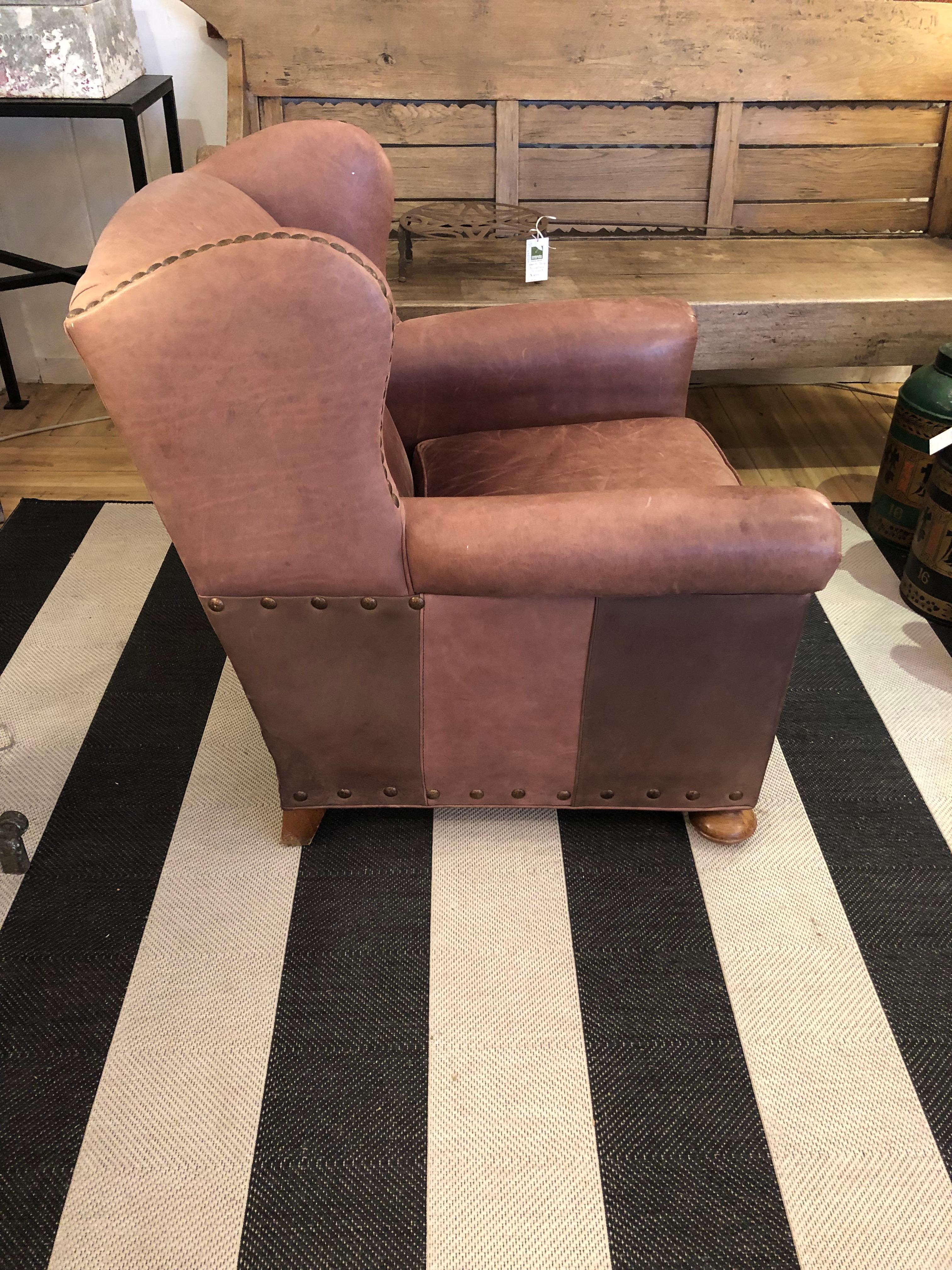 Classic medium sized soft brown leather club chair by Lee Industries having big brass nailhead detailing, bun feet and two tones of leather on the sides.  Removable seat cushion.
33.75 w at arm
29.25 w at top
arm height 22.5
seat depth 21