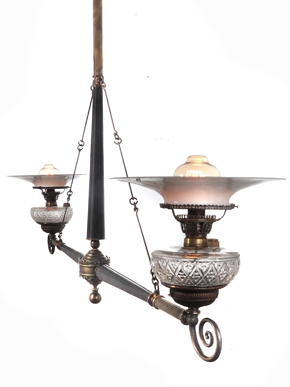 This was the type of double oil lamp found over store counters from the mid to late 1800. They were simple, utilitarian but still very stylish in detail. This example was refitted to now take a standard bulb. It spans an impressive 53 inches foot