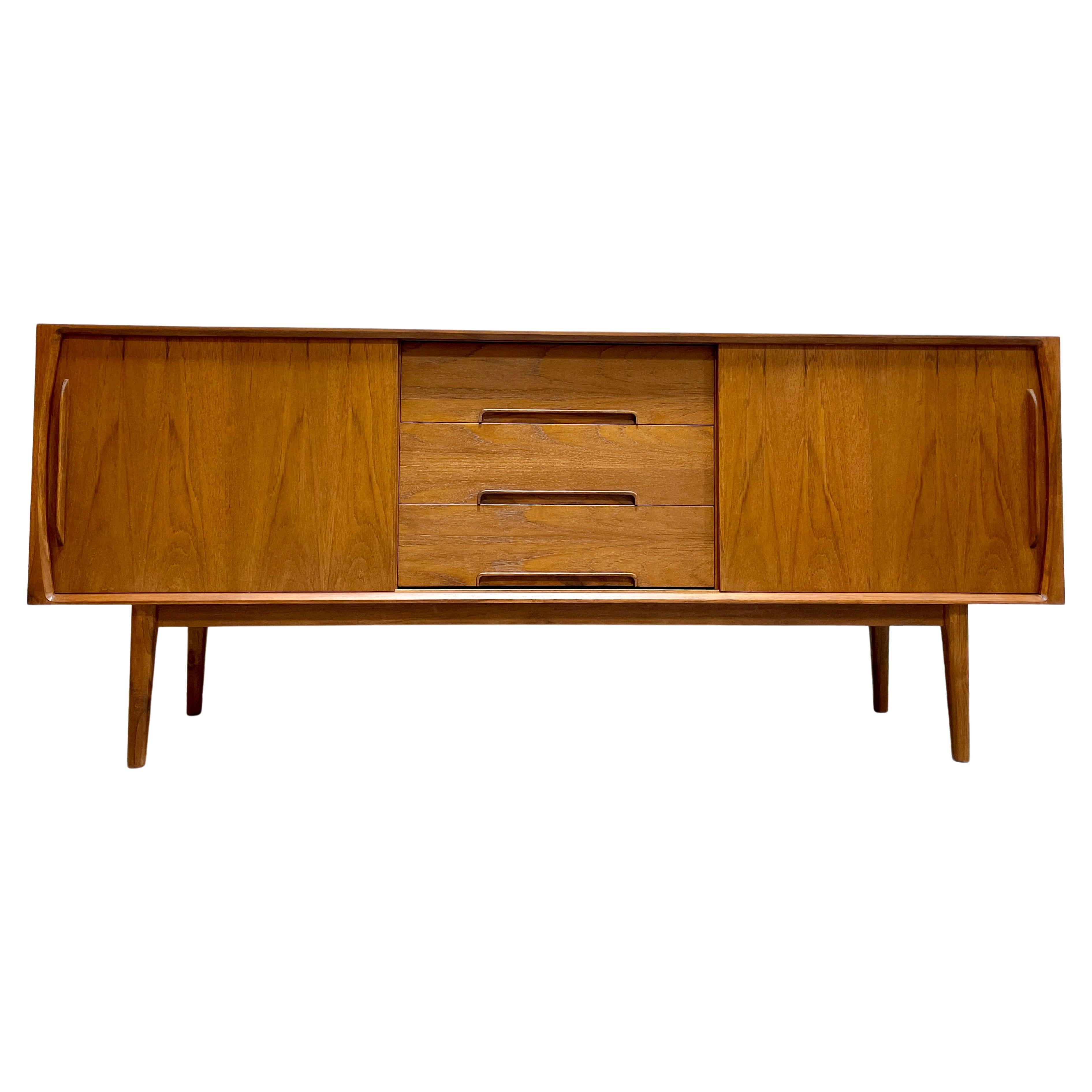 Impeccable Mid Century Modern styled Handmade Credenza featuring clean lines and gorgeous design detailing.  This credenza is highlighted by long tapered legs and intricately sculpted trim along the hand-pulls. The vast storage space offers three