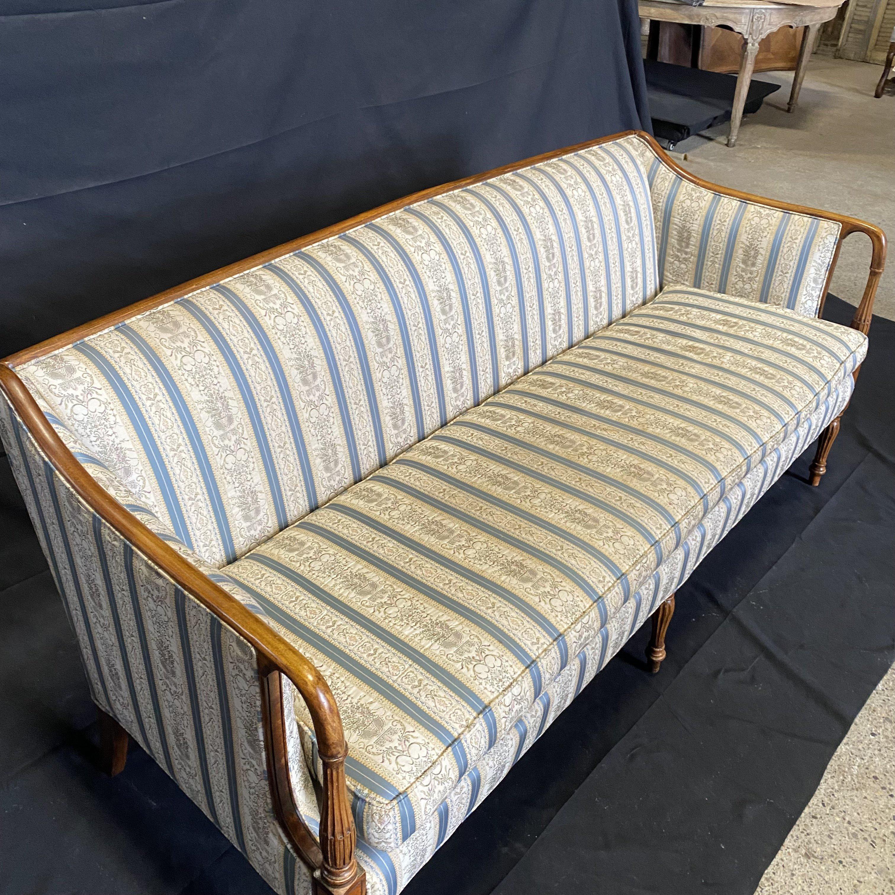 This lovely vintage sofa has carved reeded legs and arms, with graceful curves continuing around the back. 
Arm height 29