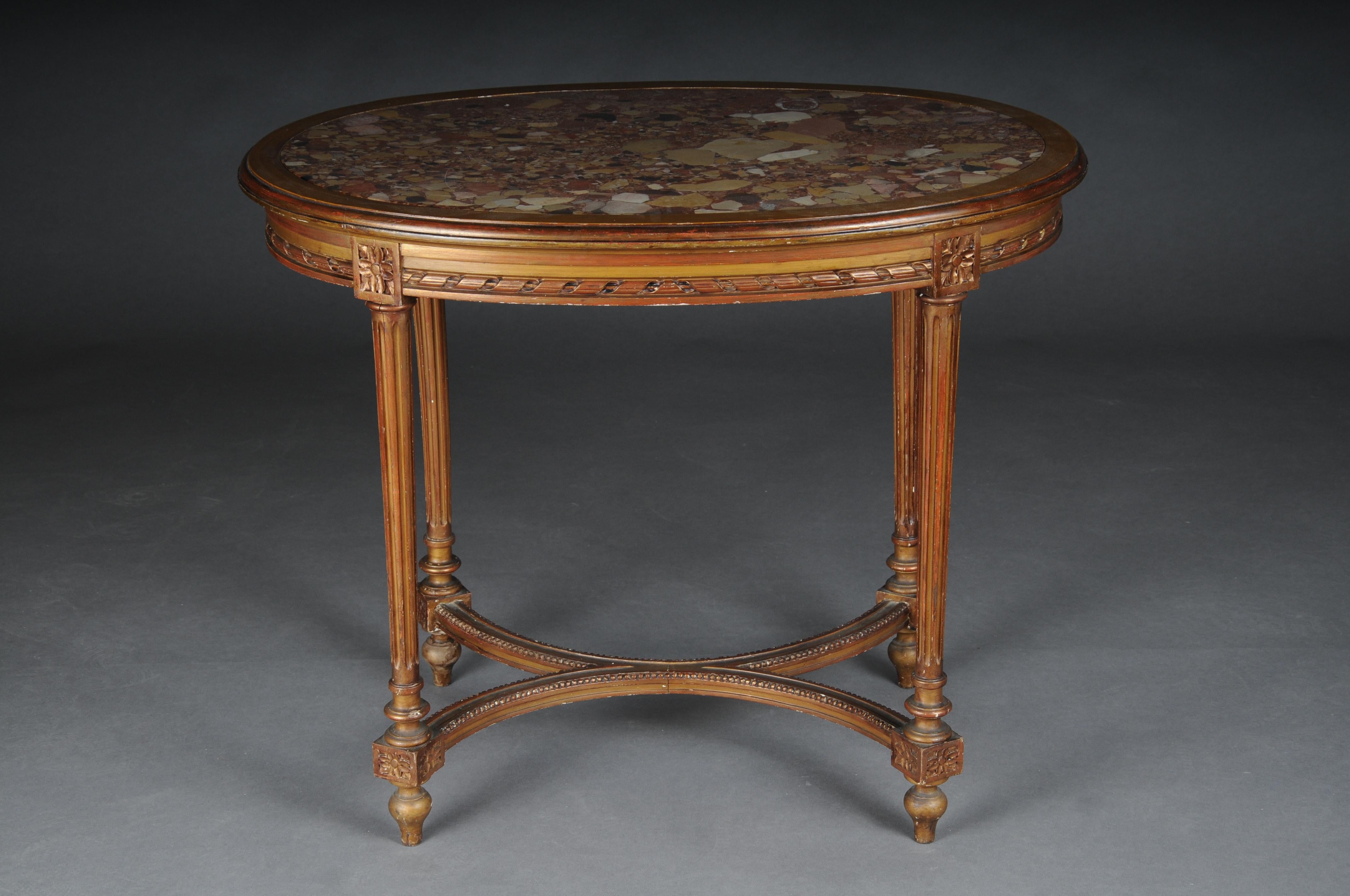 Classic Louis XVI salon table/side table, beech.

Hand-carved Louis XVI elements with tall fluted legs connected by an X-shaped bridge.

Oval mottled marble top.