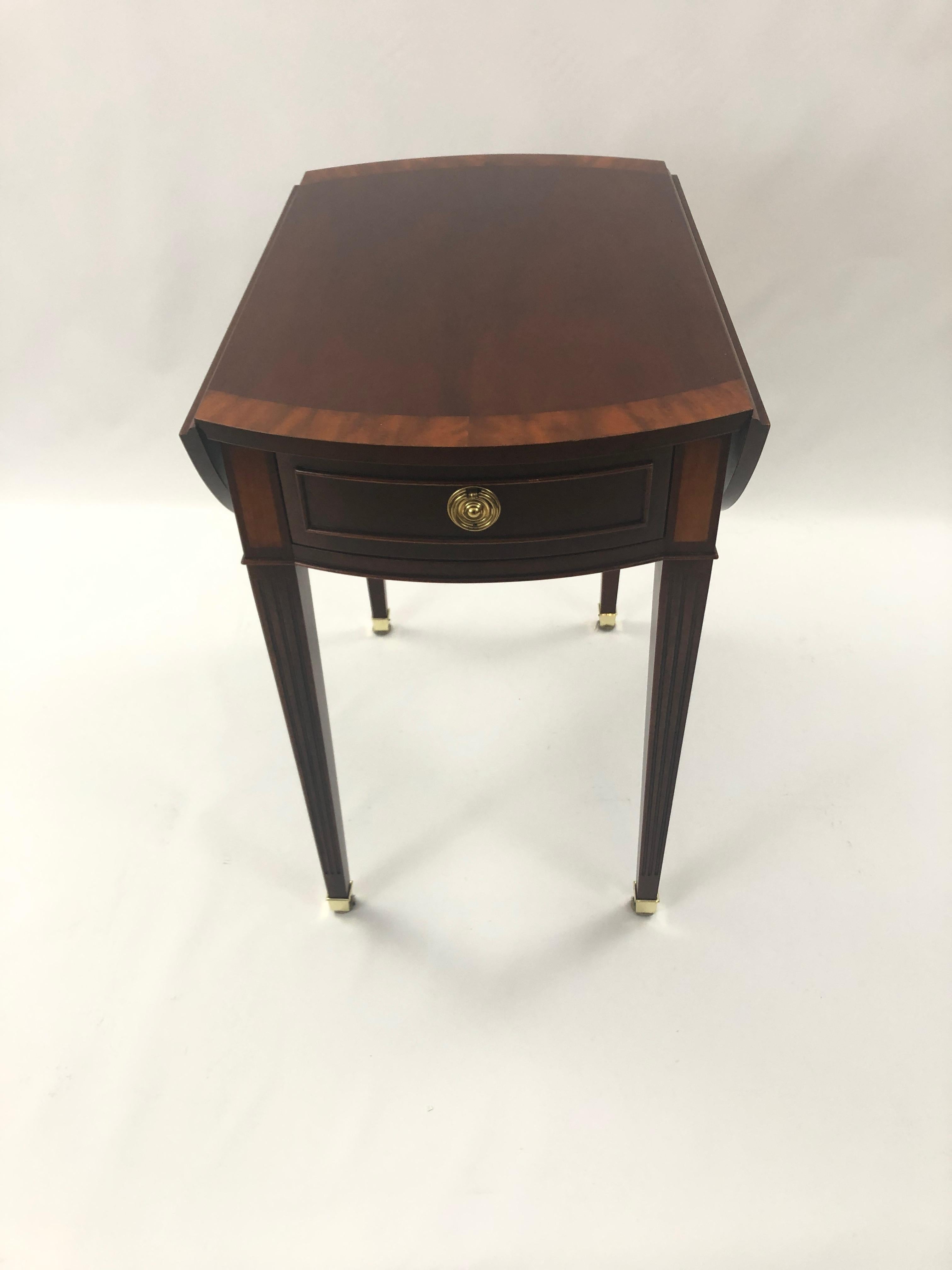 A Classic mahogany pembroke style drop leaf side table by Baker, having lovely banded inlay, single drawer, elegant tapered legs, and when open becomes an oval.
Open 31 