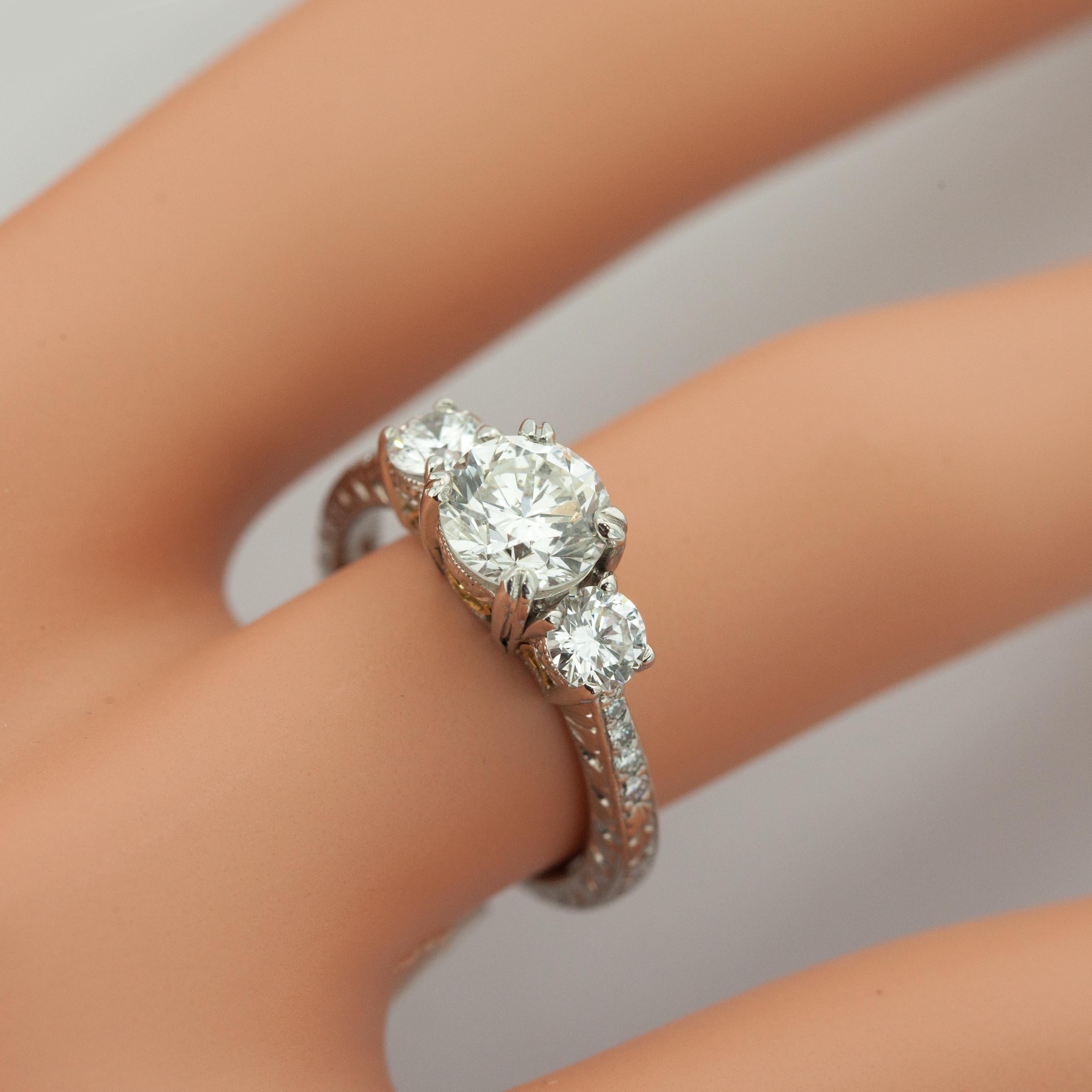 MICHAEL BEAUDRY 3-Diamond Ring with GIA Certified Center Diamond weighing 1.02 carats in H color & SI clarity. 2 side diamonds & 8 accent diamonds on the shoulders. Filigree motives  in 900 Platinum setting.

Ring Size: 4.5

Approximate Gross