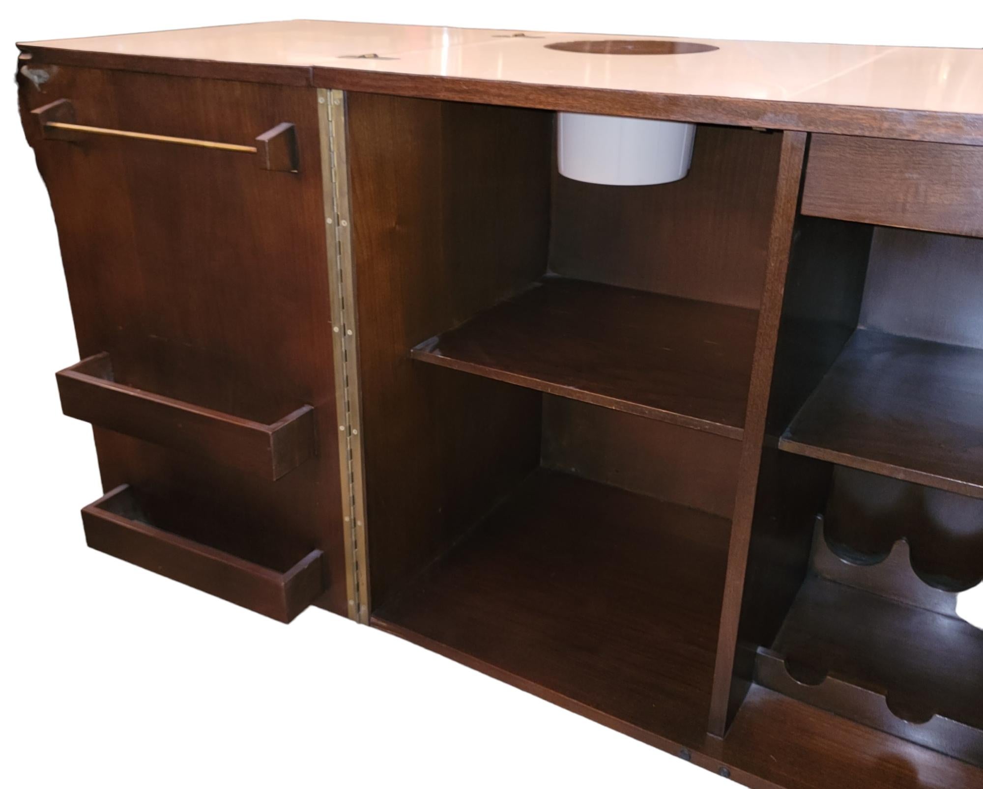 Classic midcentury Fold Out Bar. The bar opens up to old wine bottles as well as 2 shelfs on the interior with different compartments to hold all types of drinks and drink accessories. There is also a ice bucket underneath the left fold. Folded in