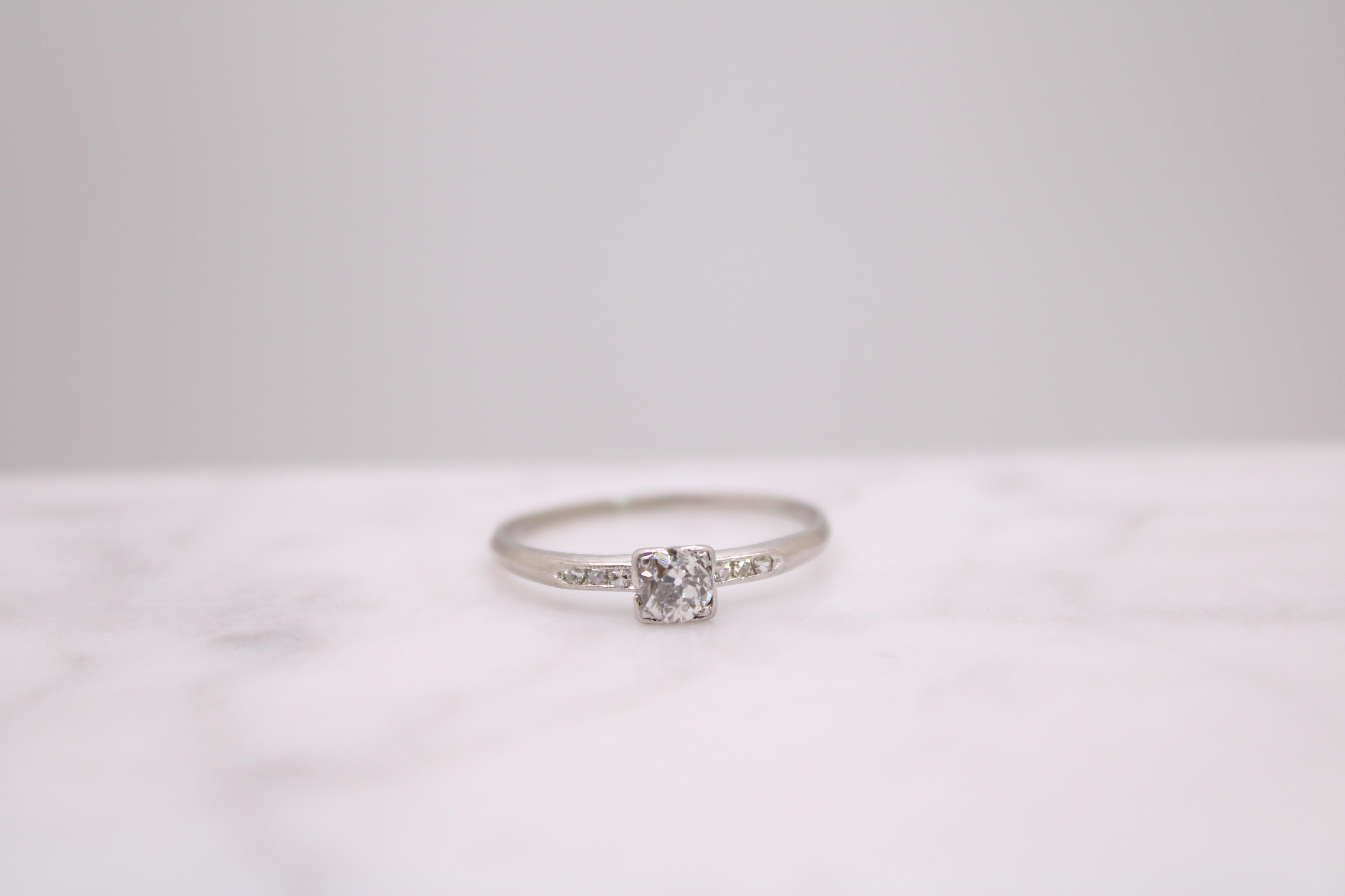 Small but mighty. This delicate ring offers mega-watt sparkle from every angle. 
But her magnificence doesn't stop there. At first glance, one would assume it is a classic mid-century engagement ring but on further inspection, it reveals a much