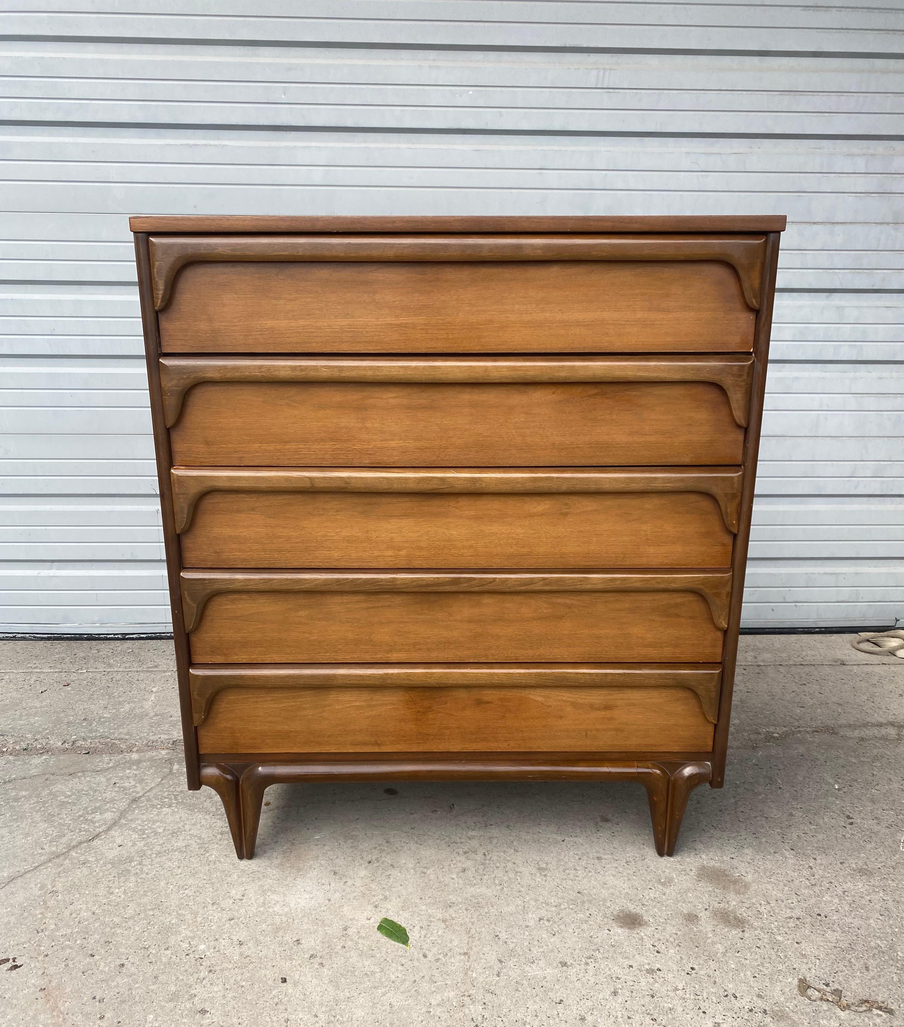 Classic Mid-Century Modern 5-drawer chest. Sculptural walnut by Bassett Furniture company. Wonderful design. Elegant yet whimsical, superior quality and construction, dove-tail drawers. Generous storage. Smooth function. Hand delivery avail to New