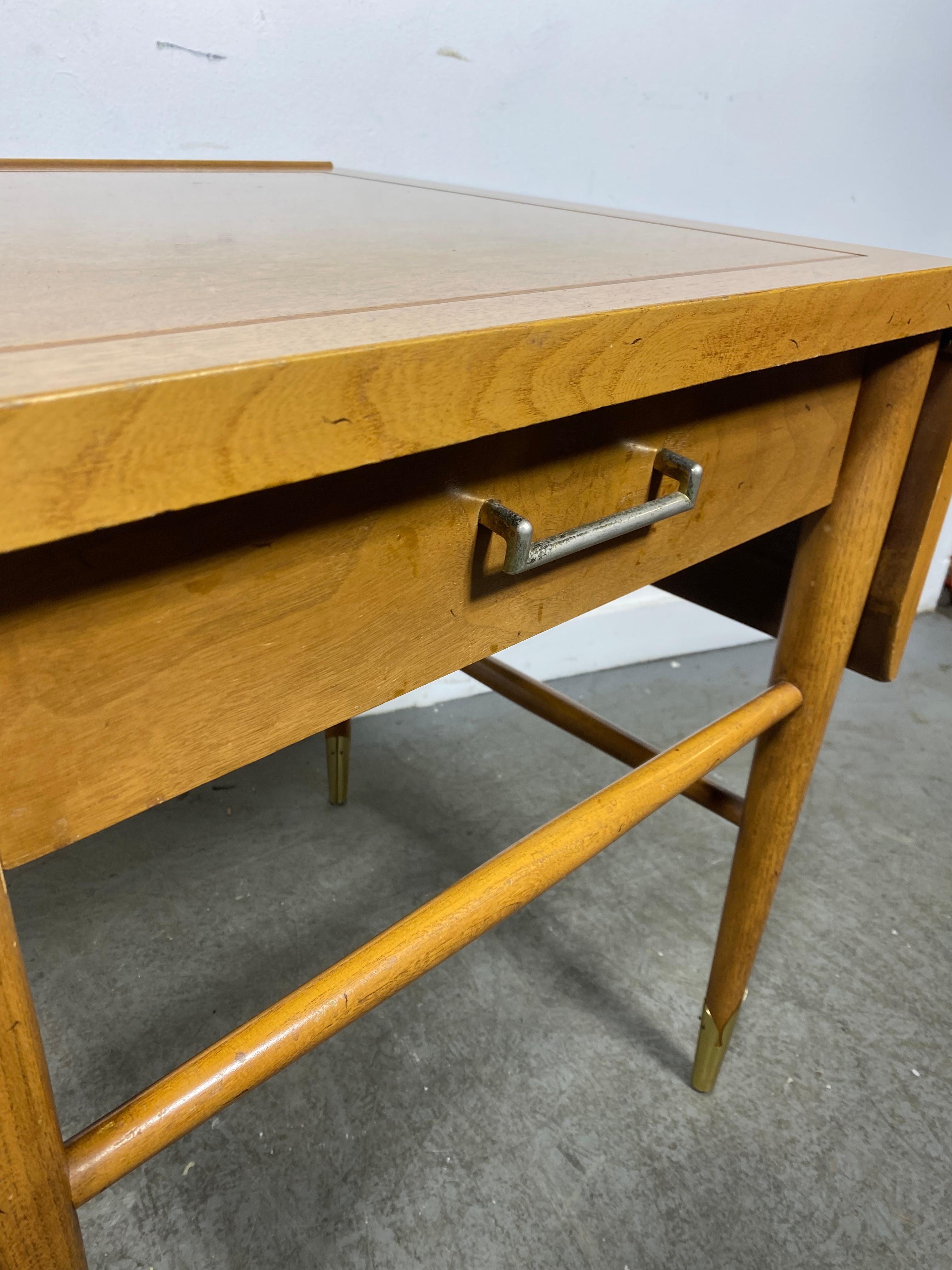 A drop leaf side/ lamp table by Lane circa 1950s from the “Copenhagen” collection. Danish meets American modern with beautiful woods and patina, tapered legs with brass sabots.  Nice original condition. Hand delivery avail to New York City or