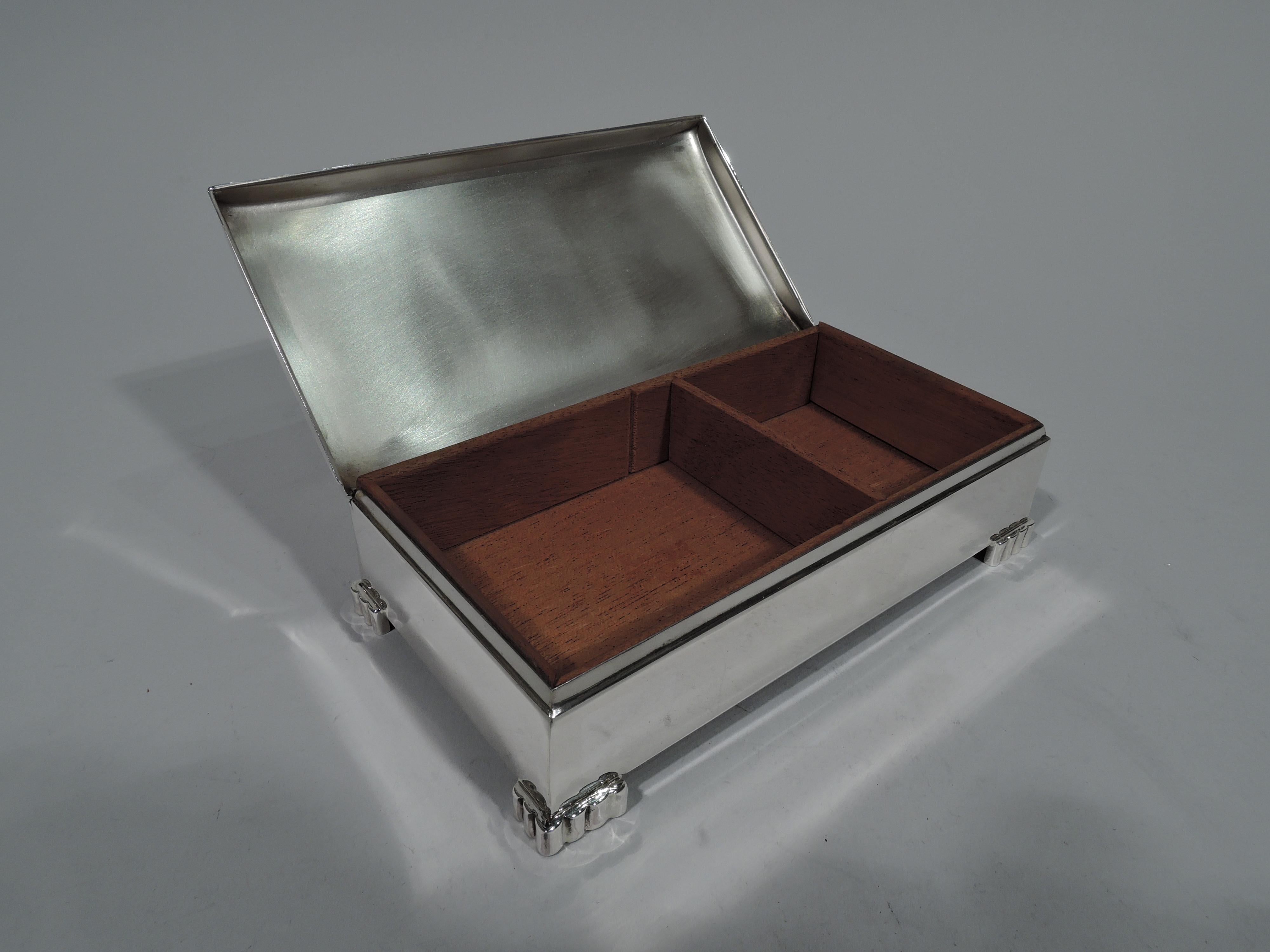 Mid-Century Modern sterling silver box. Made by Poole in Taunton, Mass. The Classic design by this maker with rectangular with straight sides and lobed bracket feet applied at corners. Cover hinged and curved. Box and cover interior cedar lined and