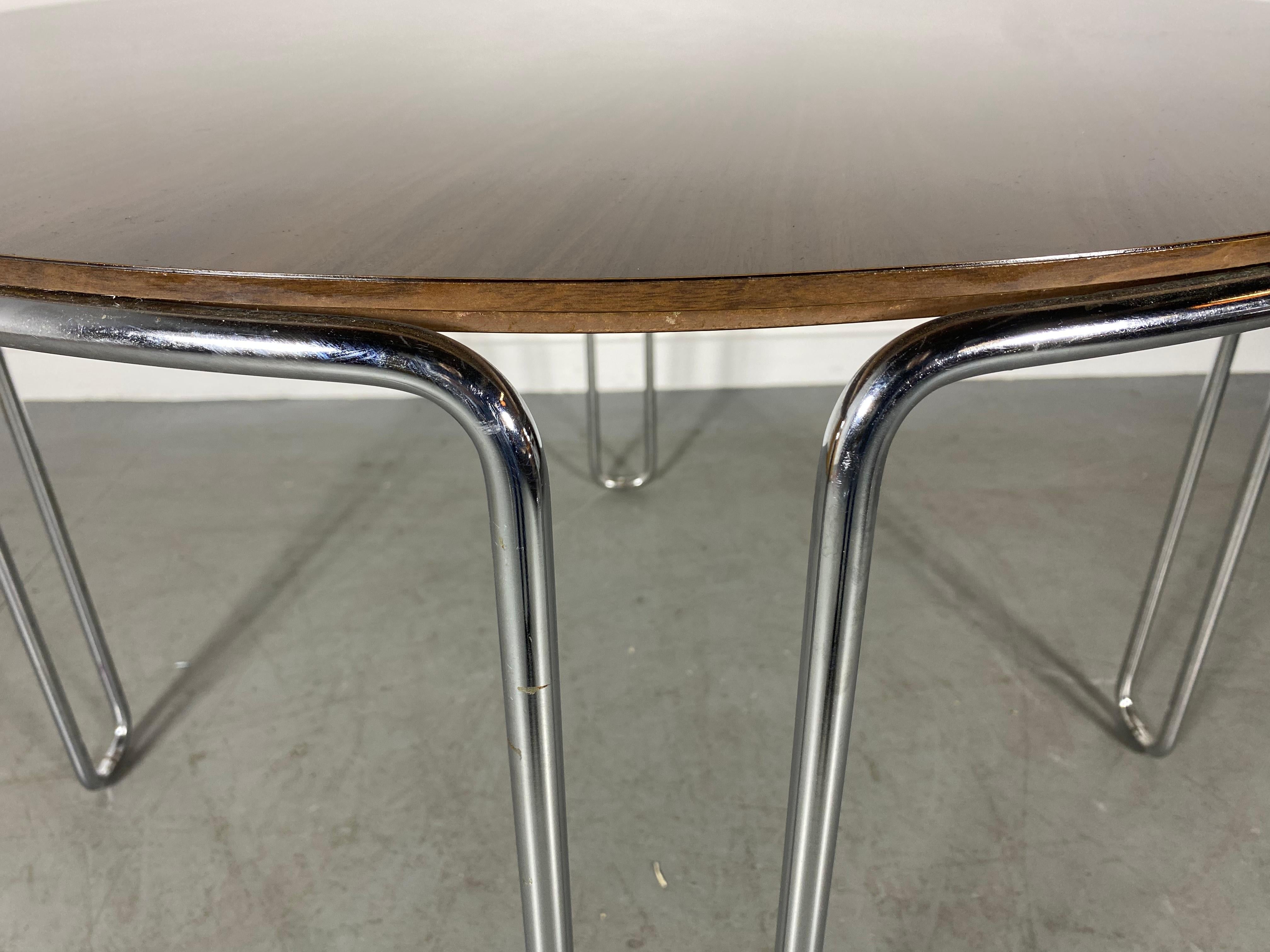 Classic Bauhaus Style Table,, reflects the influence of famed Bauhaus designer Marcel Breuer. Chrome frame and legs are bent and shaped to appear as a continuous form; faux wood top laminate surface. Great as a compact dining table or ultra chic