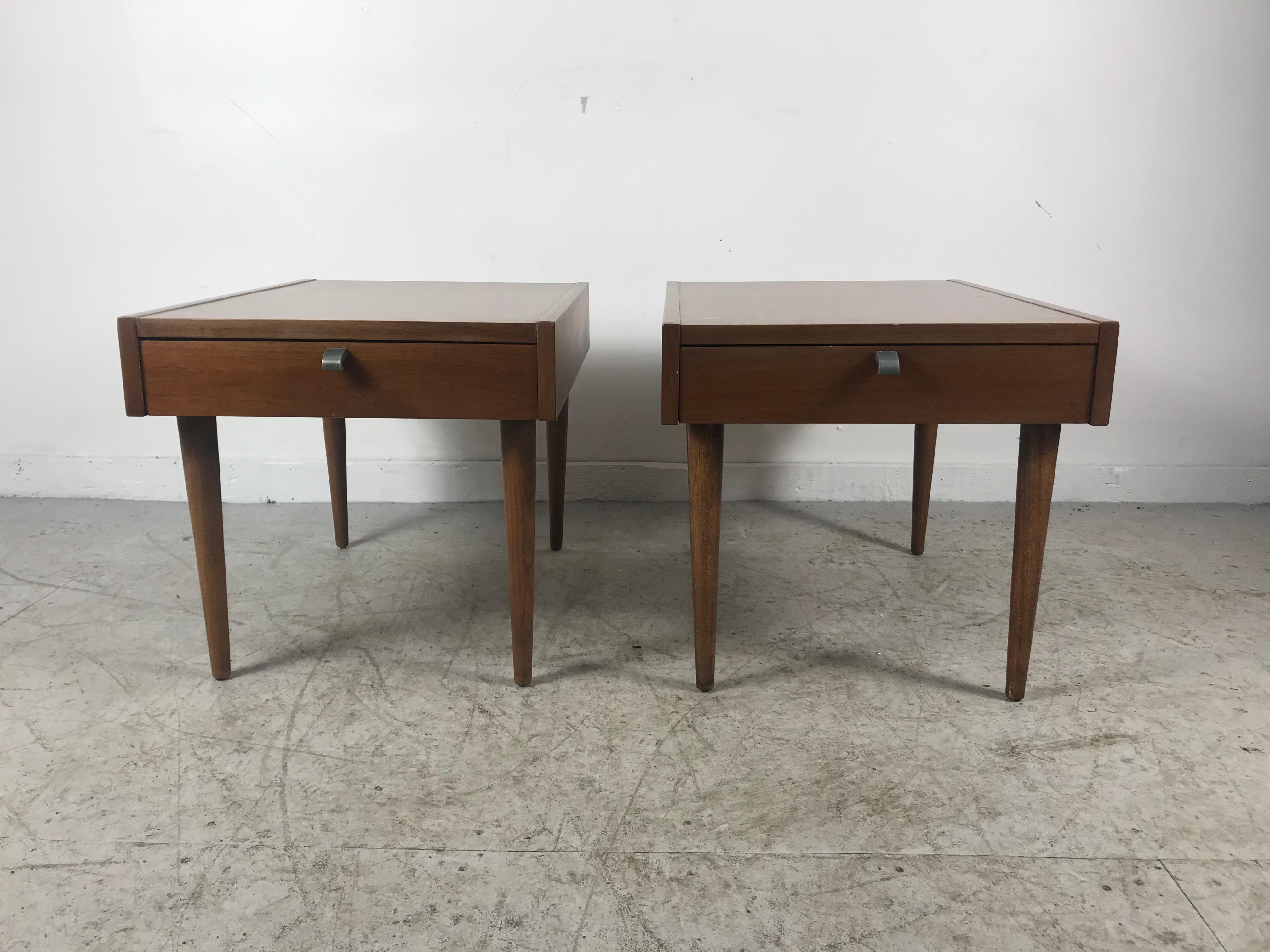 A Classic pair of vintage walnut nightstands manufactured by American of Martinsville. One drawer on each with brushed aluminum pulls and the top features X-shaped ornamental inlays in brushed aluminum.
 