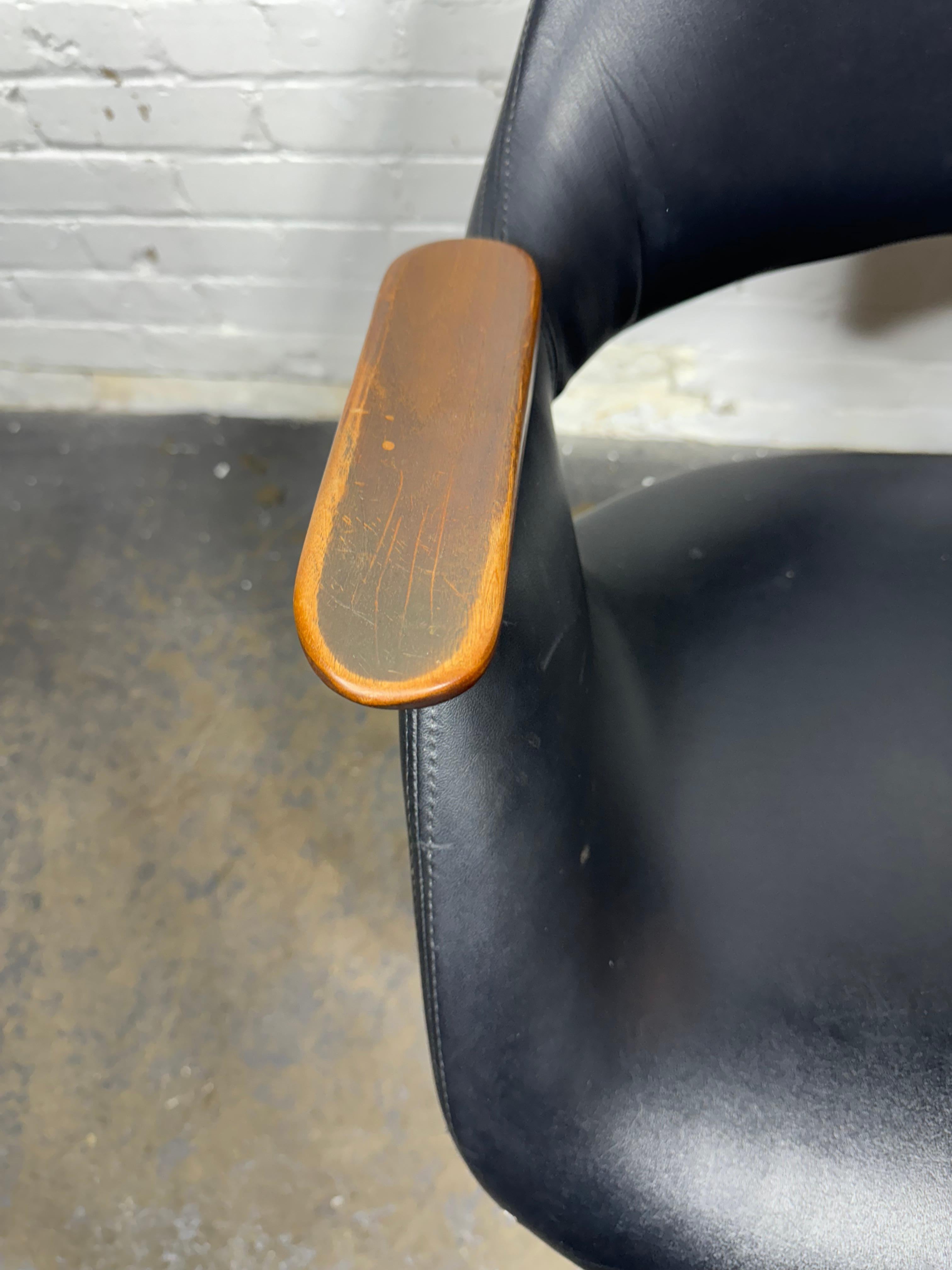 Raramente visto  poltrona da scrivania vintage Mid-Century Modern Age nera in Naugahyde no. 2635 con braccioli in legno e base a cinque punte in alluminio fuso con rotelle di Arthur Umanoff per Madison Furniture. Design classico. Ottime condizioni