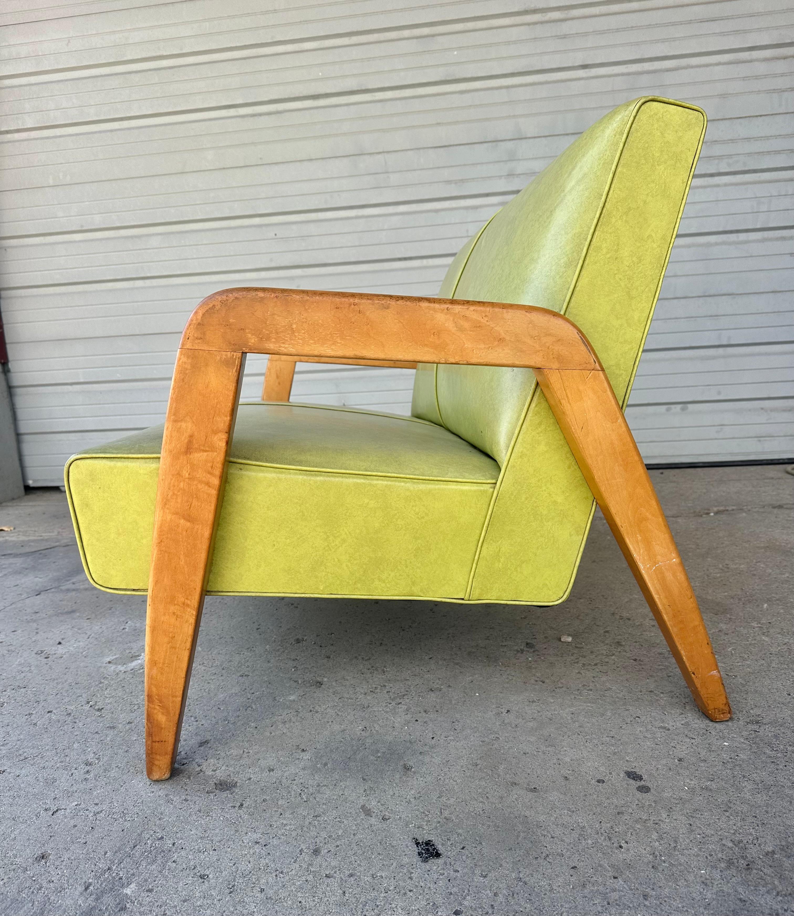A Sculpted Green Naugahyde Settee Sofa Designed by Russel Wright for Thonet, Untied States, c.1950. This Settee would look exceptional while displayed in a Mid-Century inspired interior. The solid beech wood arms are nicely sculpted and flows