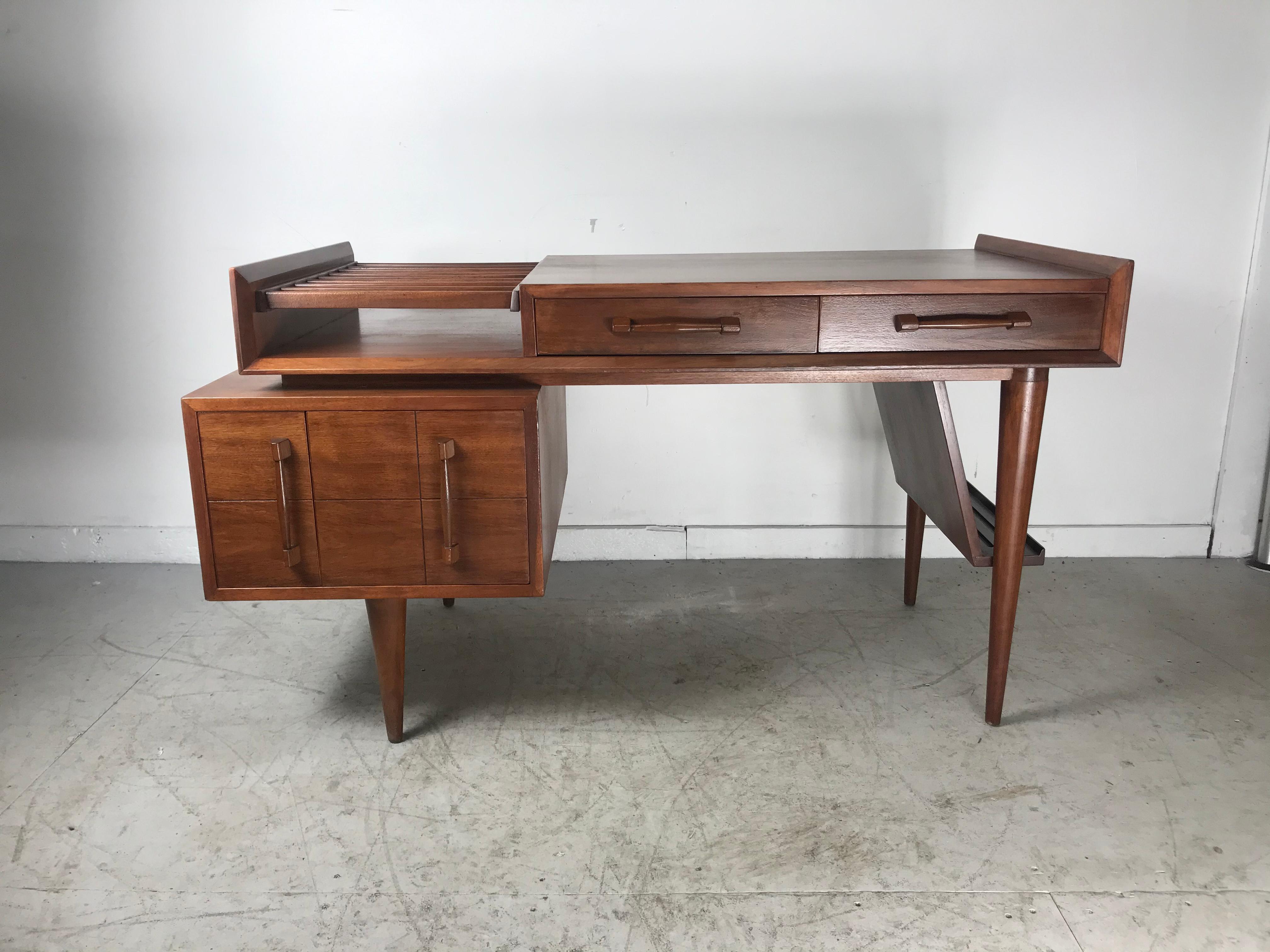 Classic Mid-Century Modern design. This piece is spectacular, an absolutely beautiful desk. Very unique styling, file drawer and side easel, it was produced by Sherman Bertram in the early 1950s. The solid walnut construction has a beautiful rich