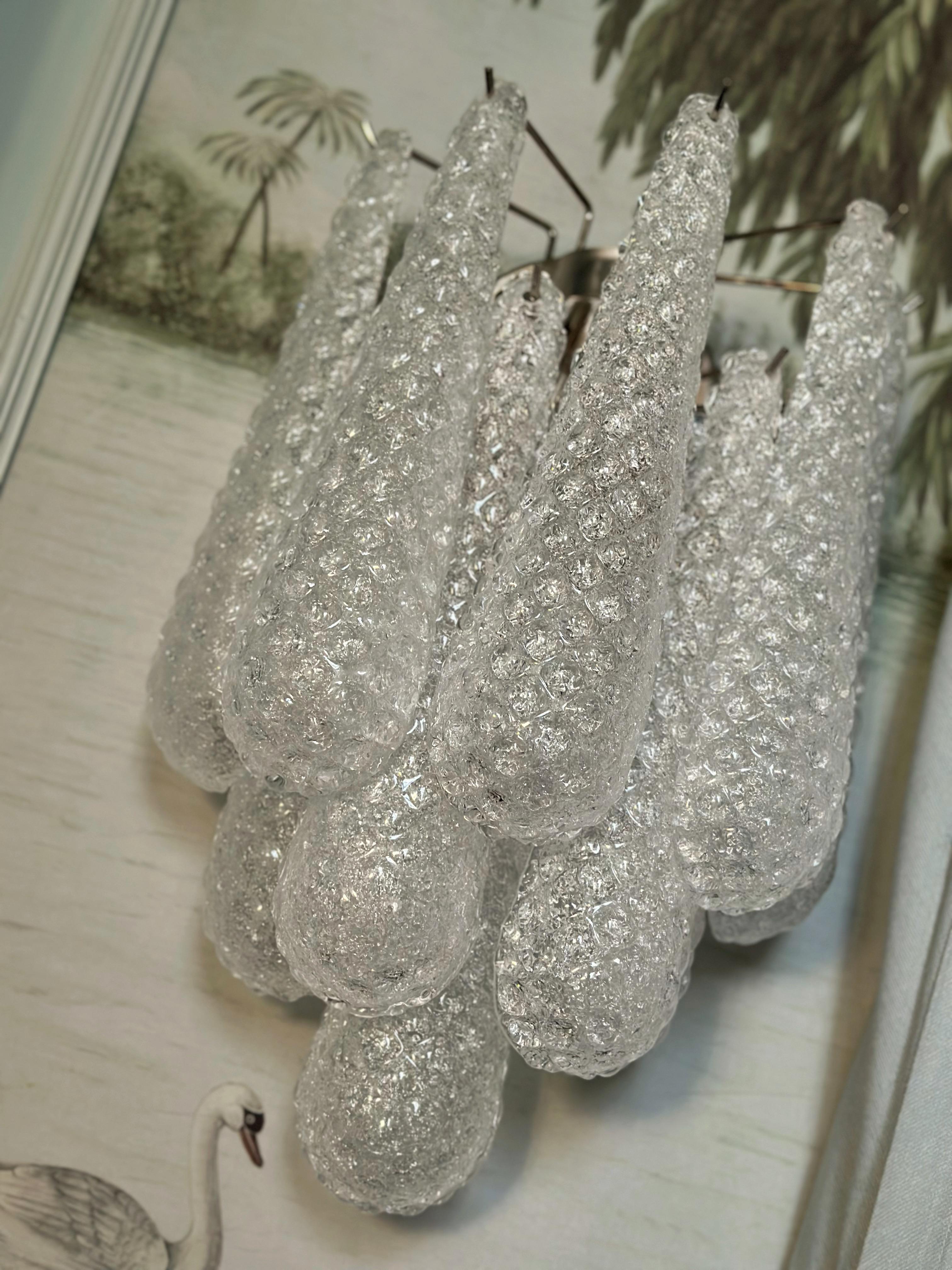 Impresionante Lámpara de Pared de Murano formada por diez gotas de cristal fijadas en un marco cromado. Estilo tradicional italiano de mediados de siglo producido en el distrito de Murano durante el siglo XXI.
Tamaño del prisma de cristal de gota: