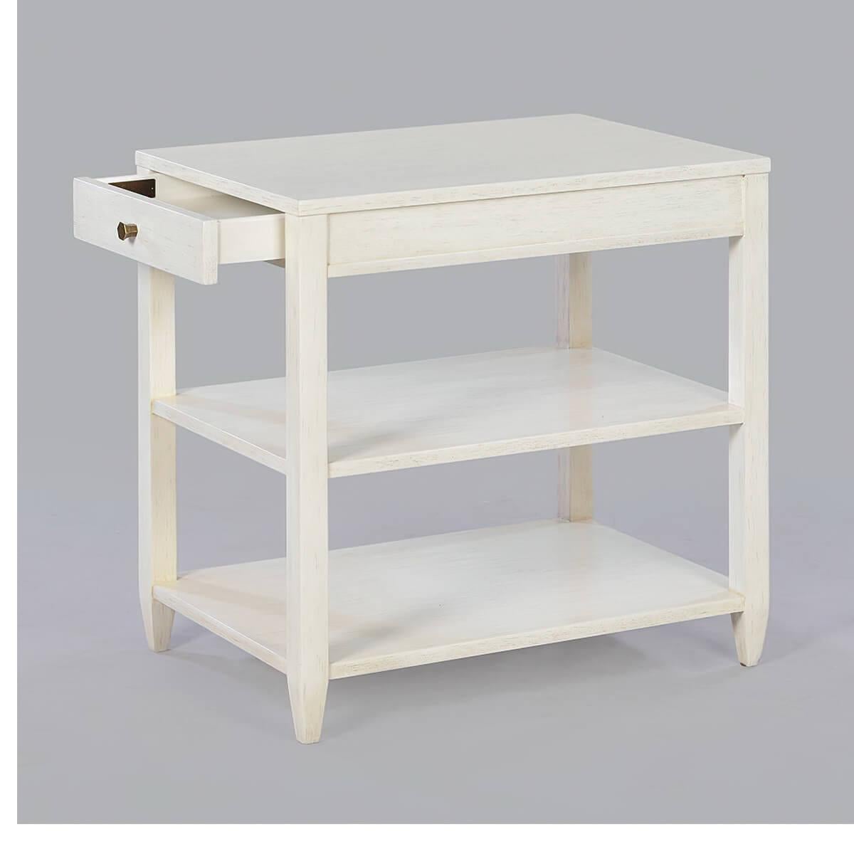 Classic narrow rectangle side table with a drawer, two shelves, brass hardware, and tapered teen, has a “drift” white painted finish with a subtle grey distressing and hand-rubbed finish.

Dimensions: 26