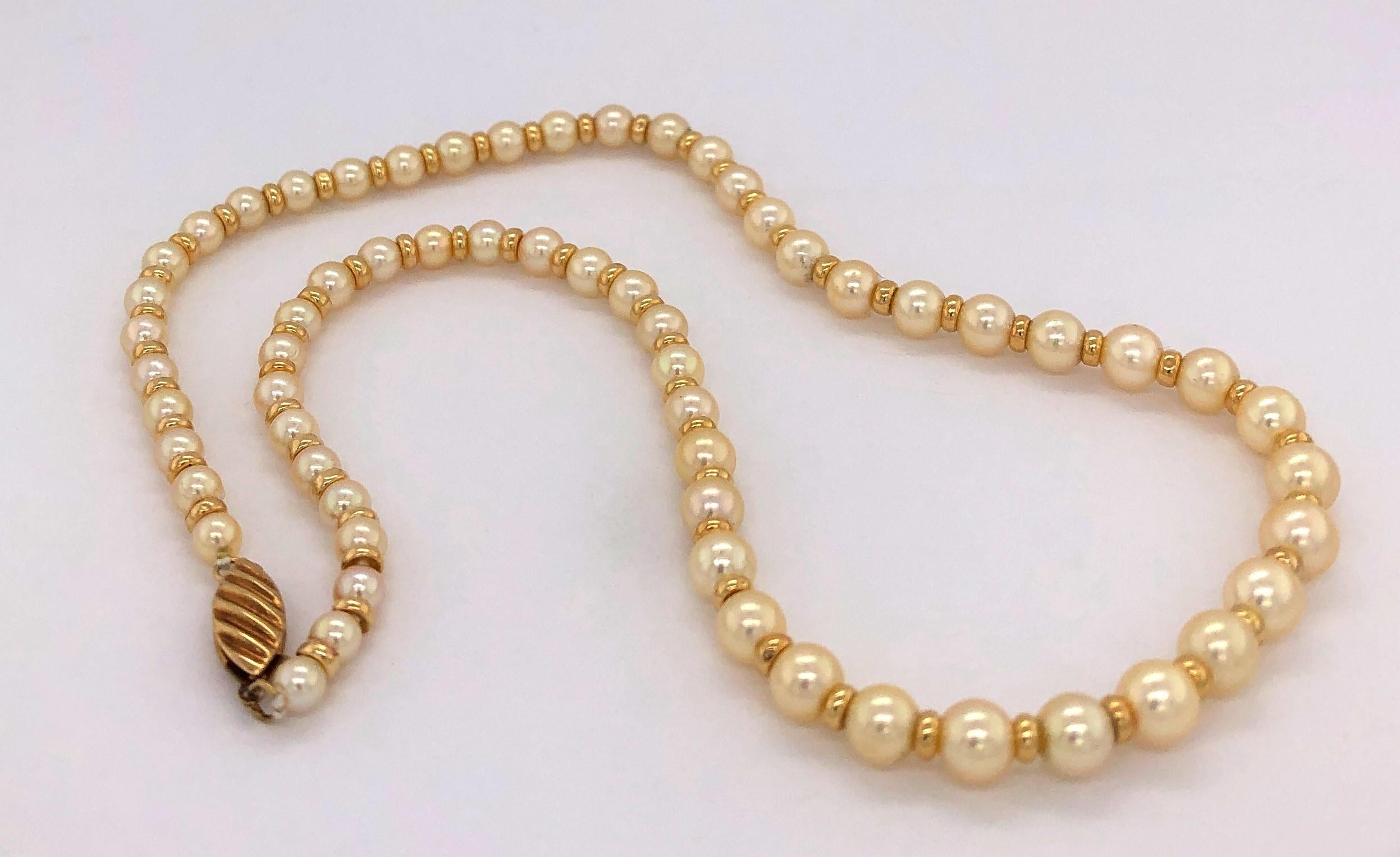 Schlichte Eleganz beschreibt diese vierzehn Zoll lange Halskette aus abgestuften Akoya-Perlen von 3,5 mm bis 5,5 mm, die mit vierzehn Karat Gelbgoldperlen zwischen den einzelnen Perlen von Hand aufgereiht sind. Der Strang ist mit einer dekorativen