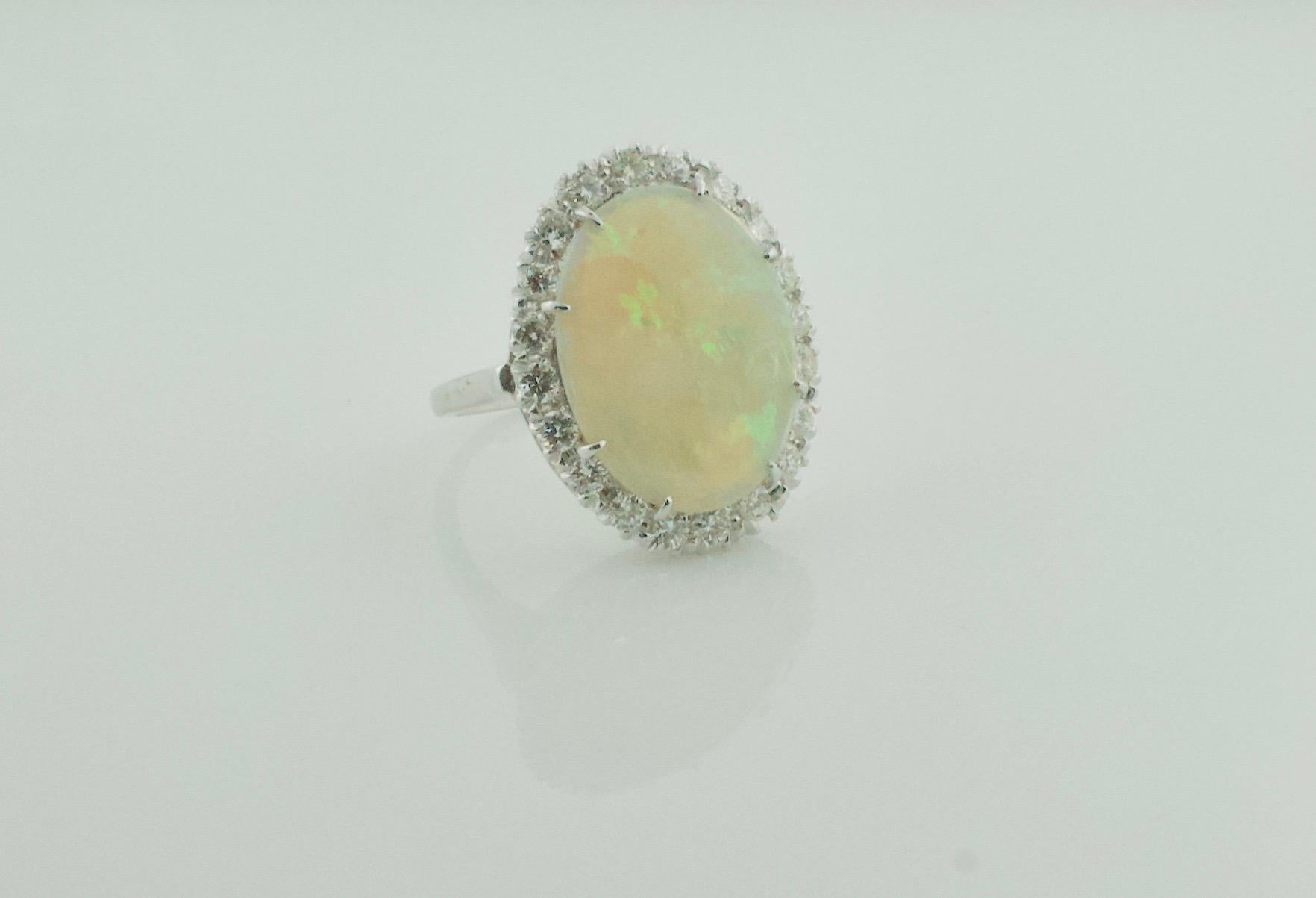 Classic Opal and Diamond Ring in 14k White Gold Circa 1960's
One Cabochon Opal Weighing 7.00 Carats Approximately [great play of colors no surface or internal crazing]  
20 Round Brilliant Cut Diamonds Weighing .80 Carats Approximately 
Excellent 