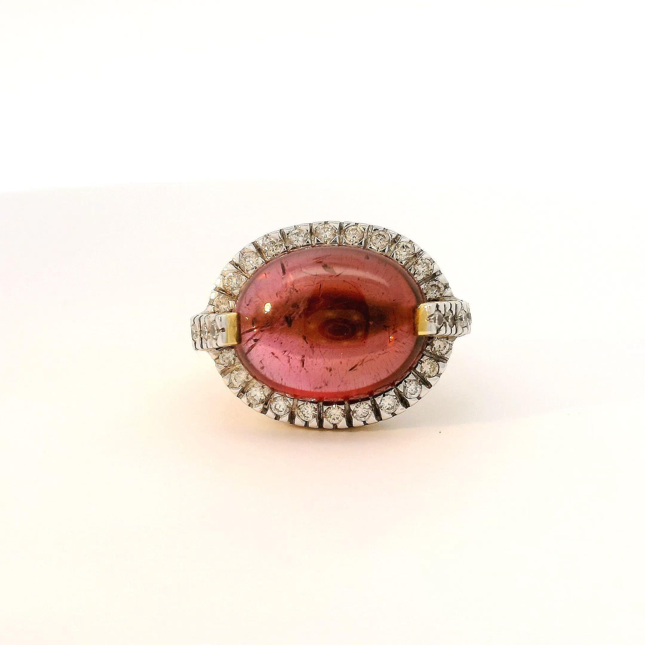 Realizzato con un'attenzione meticolosa ai dettagli, questo pezzo presenta una radiosa tormalina rosa ovale tagliata a cabochon da 9,995 carati come pezzo centrale. Circondato da un'aureola di diamanti scintillanti da 0,43 carati incastonati