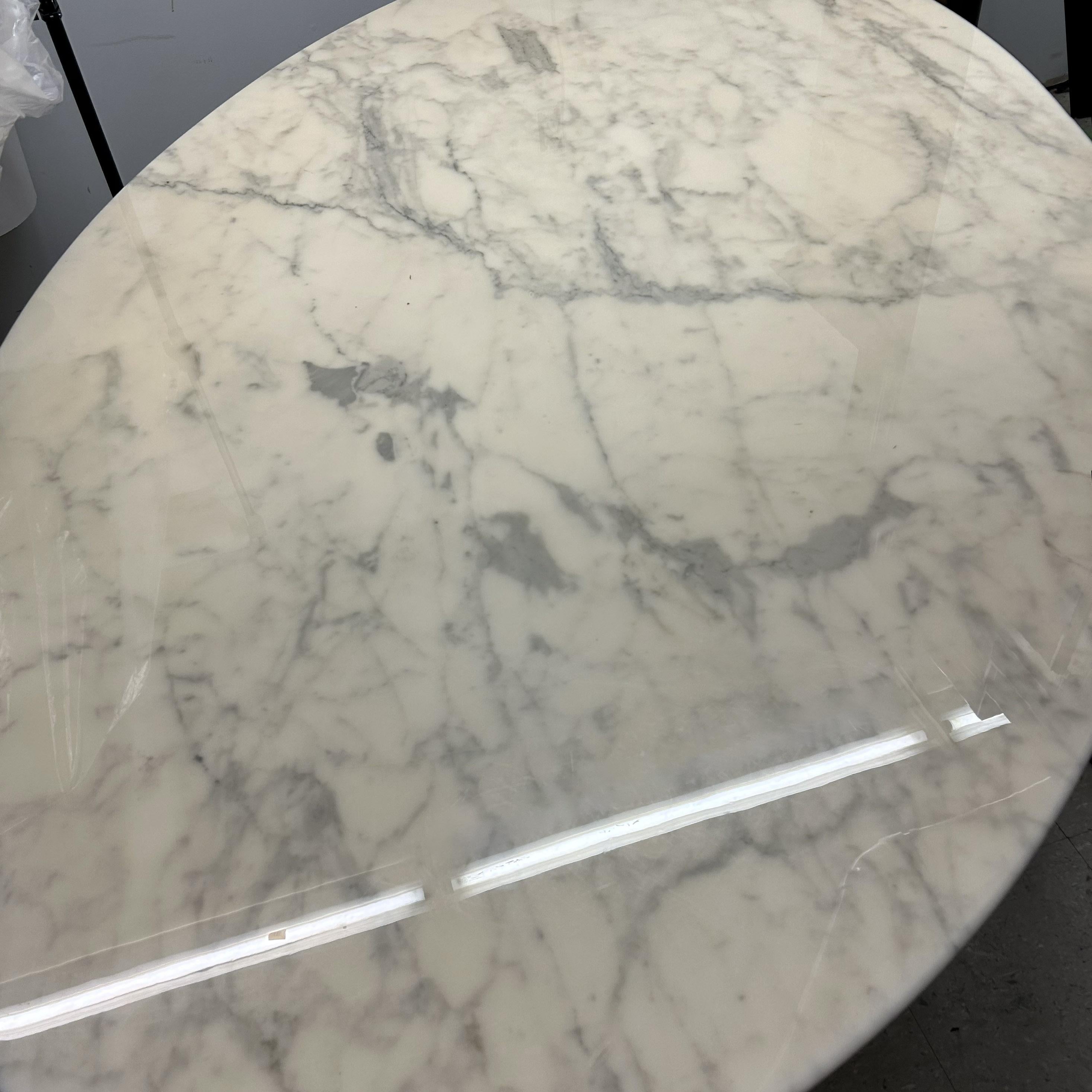 Florence Knoll's Classic Mid-Century Modern oval dining table with marble top was designed and produced in the 1960s. This luxurious marble table top features a beautiful cool gray veining throughout and is set on a heavy gauge chromed steel base
