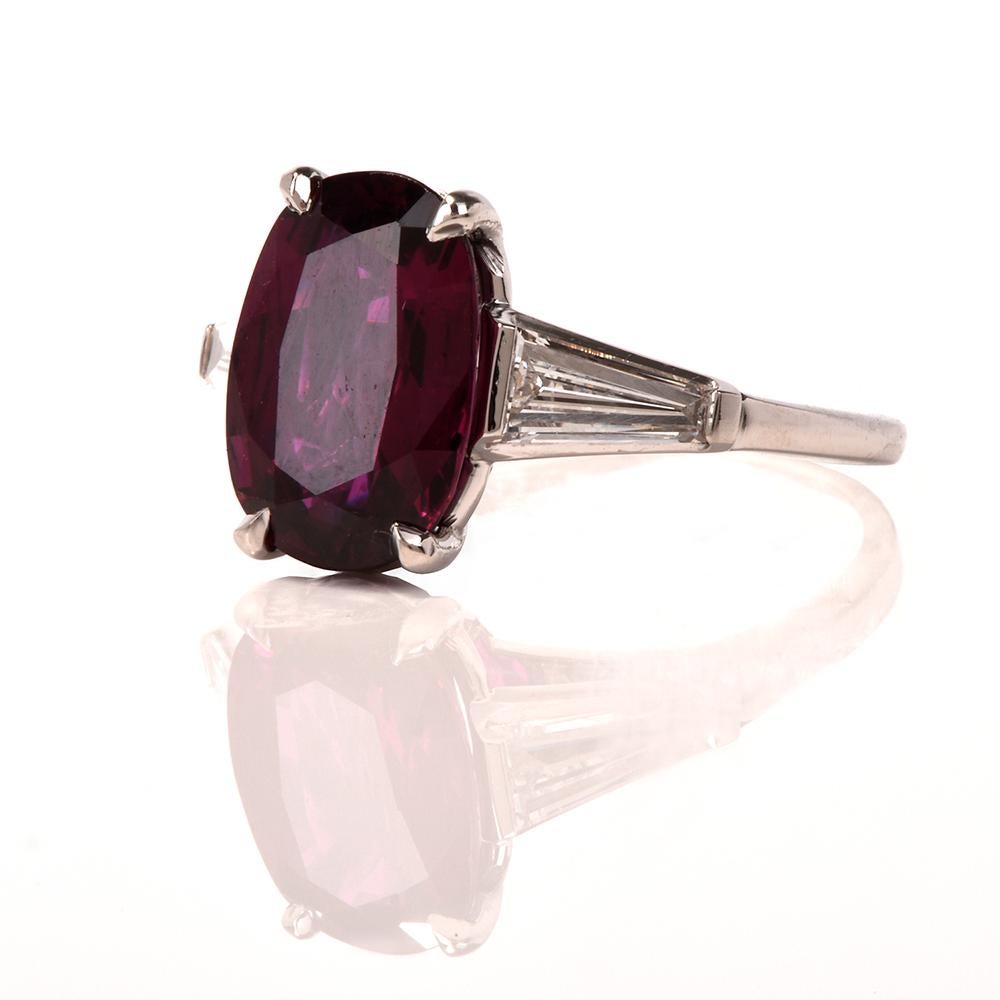 This exquisite handcrafted oval ruby and diamond ring is designed in solid platinum. Center exposes a genuine Ruby weighing 4.10 carat measuring 11.65 x 8.16 x 4.34. Flanked by 2  large Baguette-cut diamonds, cumulatively weighing 0.80 carats in