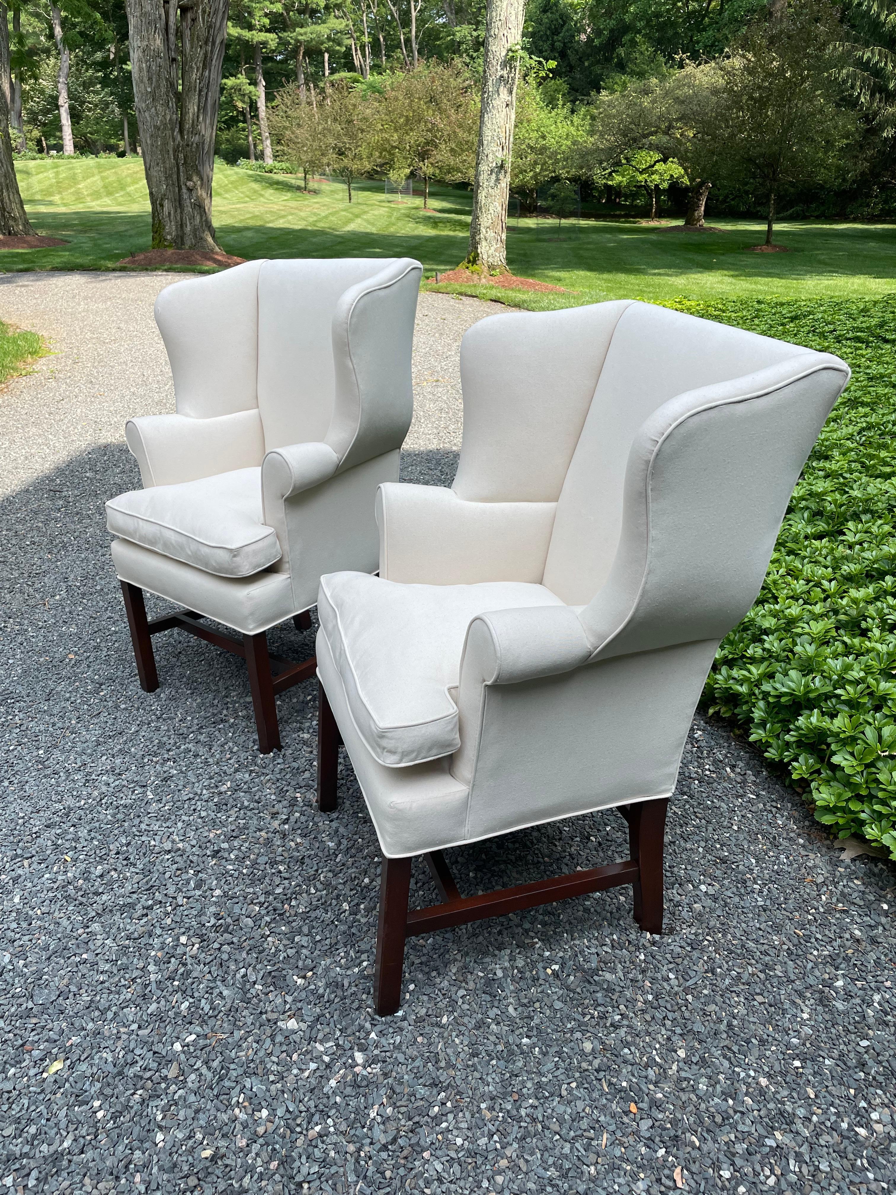 Elegantes Paar georgianischer Ohrensessel im Vintage-Stil, die kleiner sind als viele der größeren Modelle.  Die Stühle sind neu gepolstert und mit weißer Baumwoll-Ente und Daunenkissen ausgestattet.  Schöne Mahagoniträger und -beine.
Sitztiefe 16
