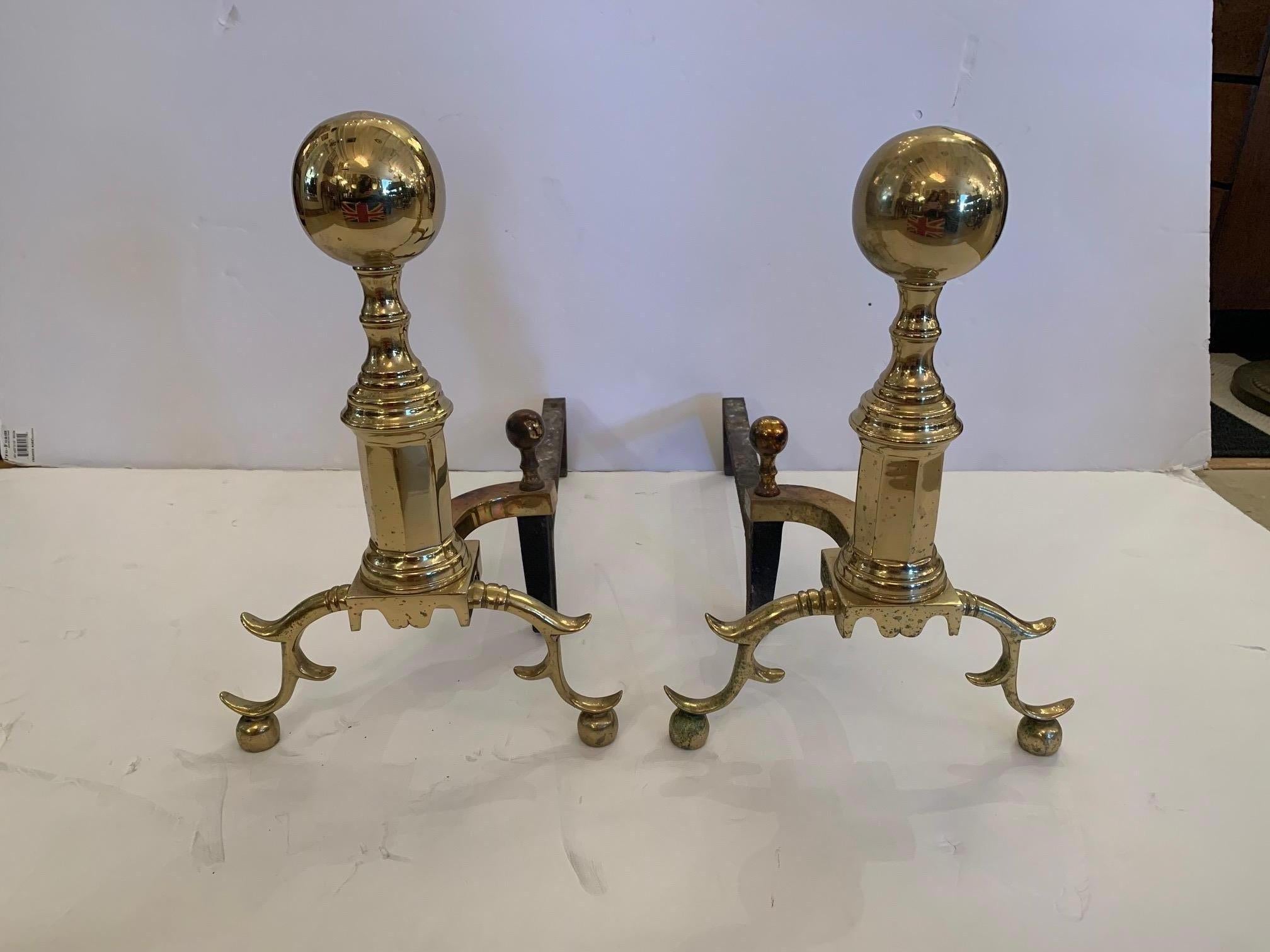 Classically elegant brass pair of brass cannonball style andirons having pretty curved side legs and ball feet.