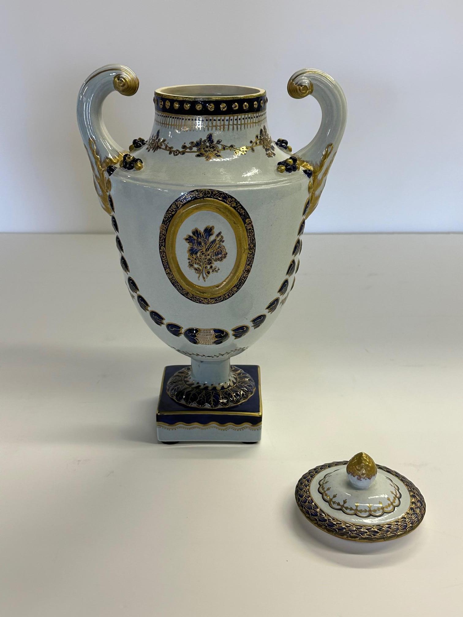Beautiful classic pair of Mottahedeh painted Chinese Export style lidded urns having a striking color palette of white, blue and gold.
Bases arae 4 x 4.