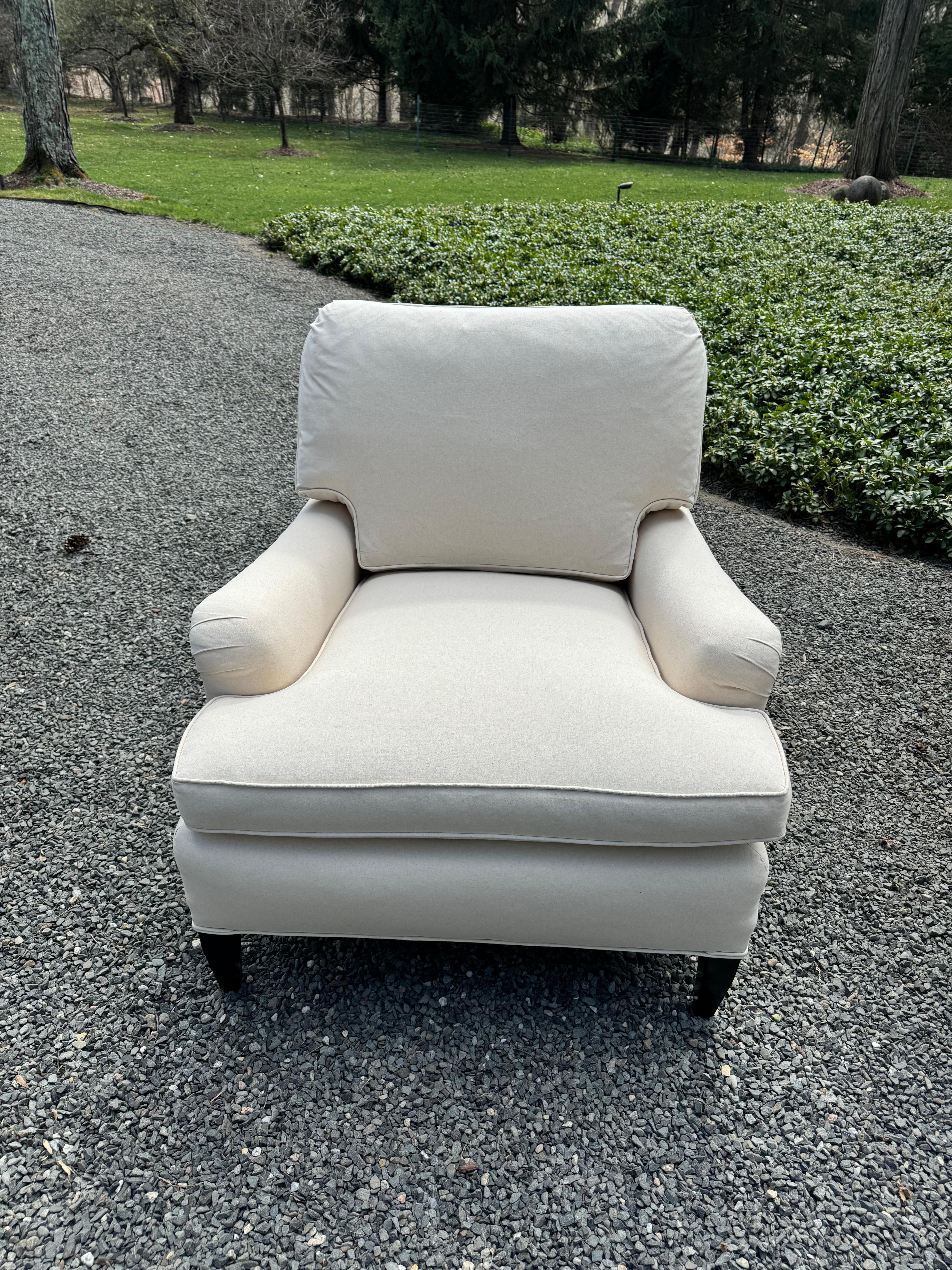 Classic pair of very comfortable luxurious newly upholstered club chairs having clean, crisp off white cotton duck fabric, with sophisticated silhouette.  Loose back and seat cushions; ebonized legs.  
Seat depth 27
seat interior width 23
arm height