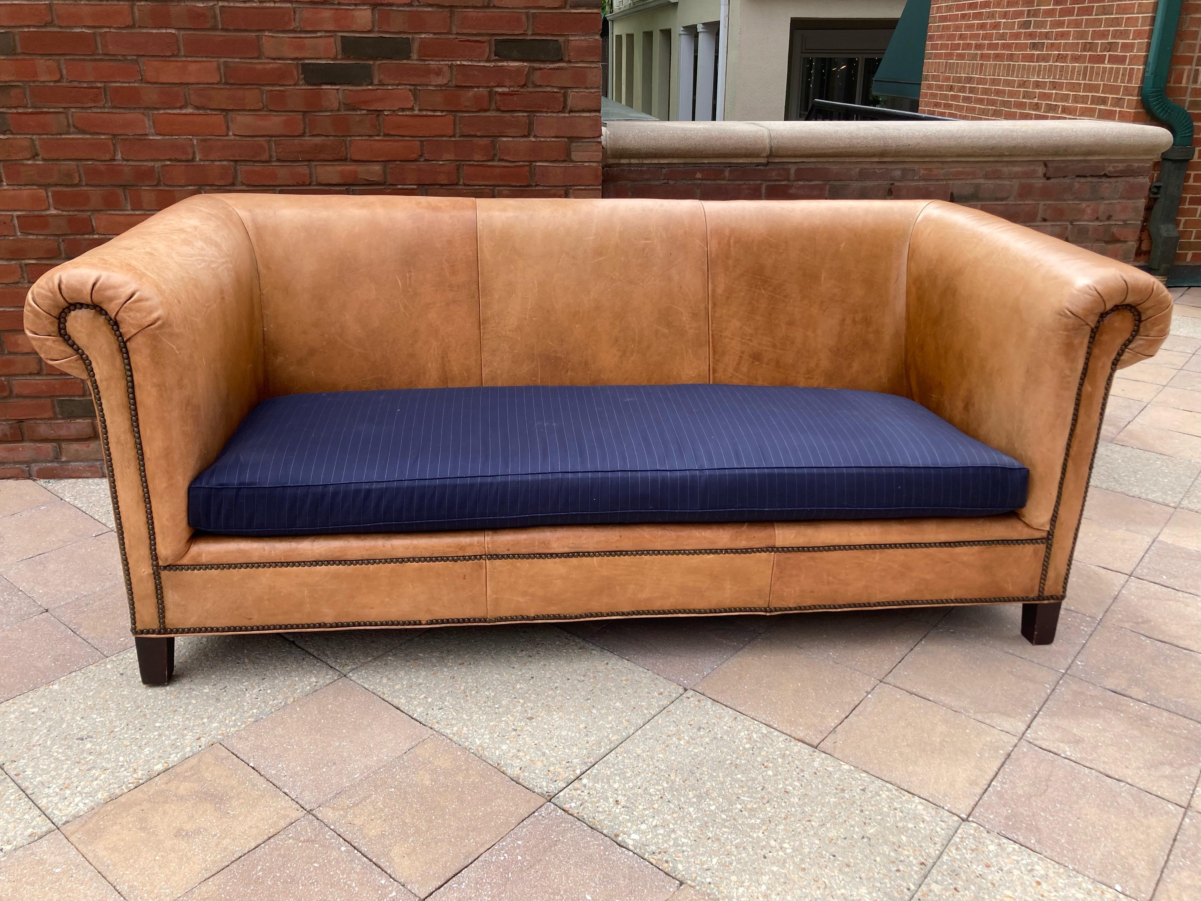 Yummy classic pair of Ralph Lauren Brompton style saddle colored supple leather Chesterfield sofas with nail head trim, wooden feet and high end navy twill gray striped very comfy seat cushions. Covers are removeable and cushions are foam wrapped in