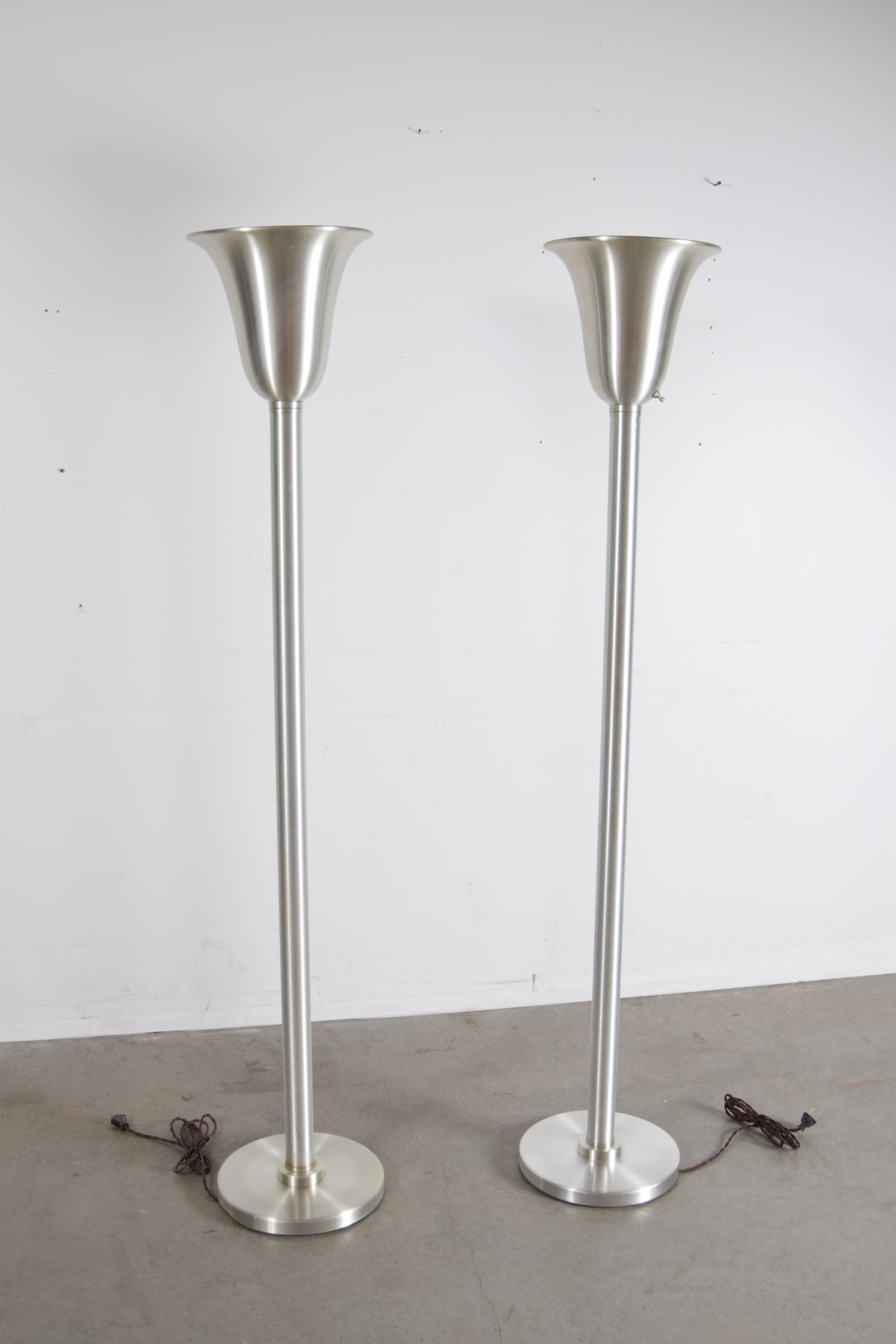 Classic pair of spun aluminum torchieres attributed to Russel Wright, circa 1947. In absolutely amazing condition for their age. Professionally re-wired for safety. They Stand 65
