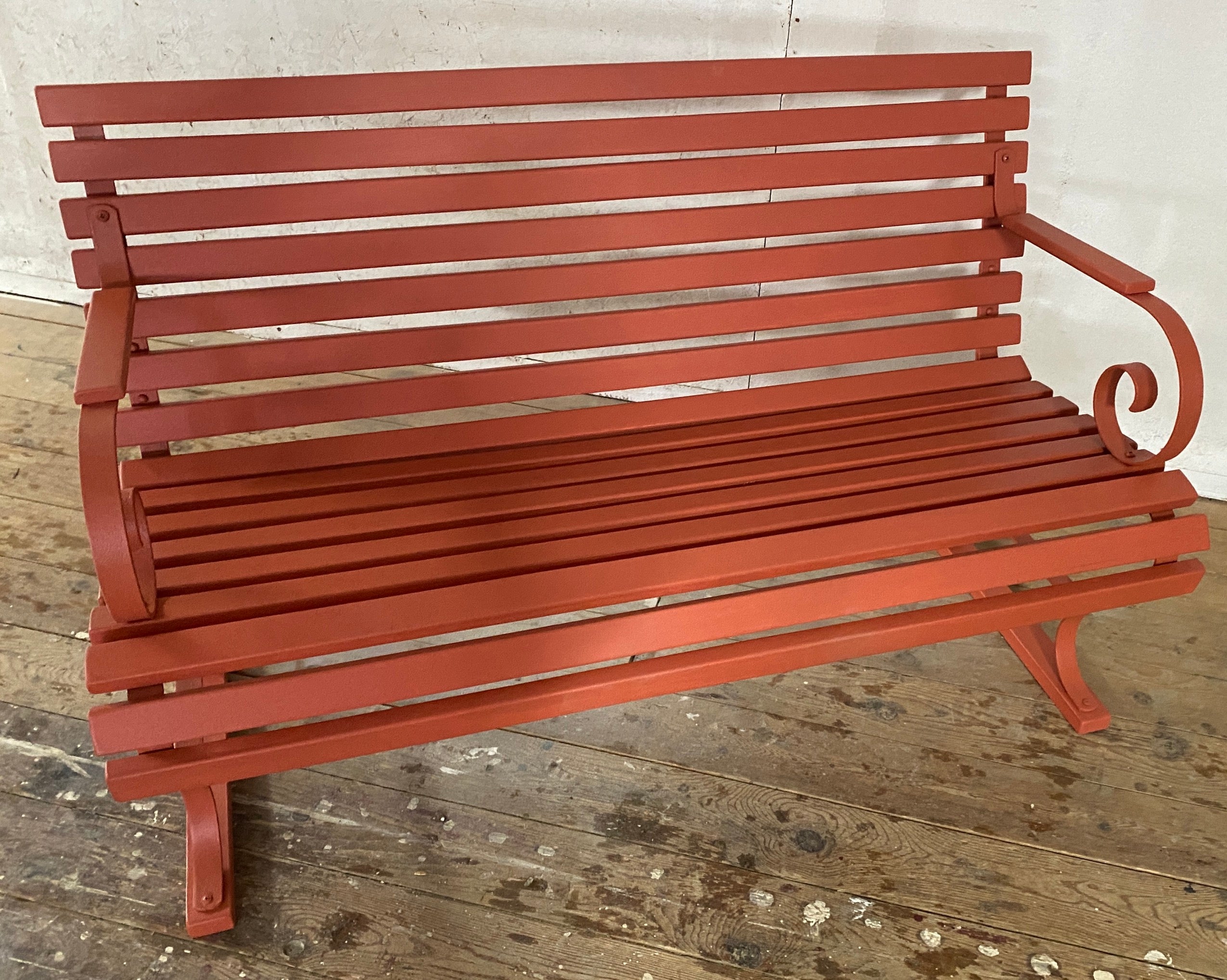 A classic late 19th century, slat design wrought iron park / garden bench with wood slat seat and back. The iron metal frame has graceful curved arms and legs. . 
Wonderful additional seating for a garden dining or under a tree.
Also available, a