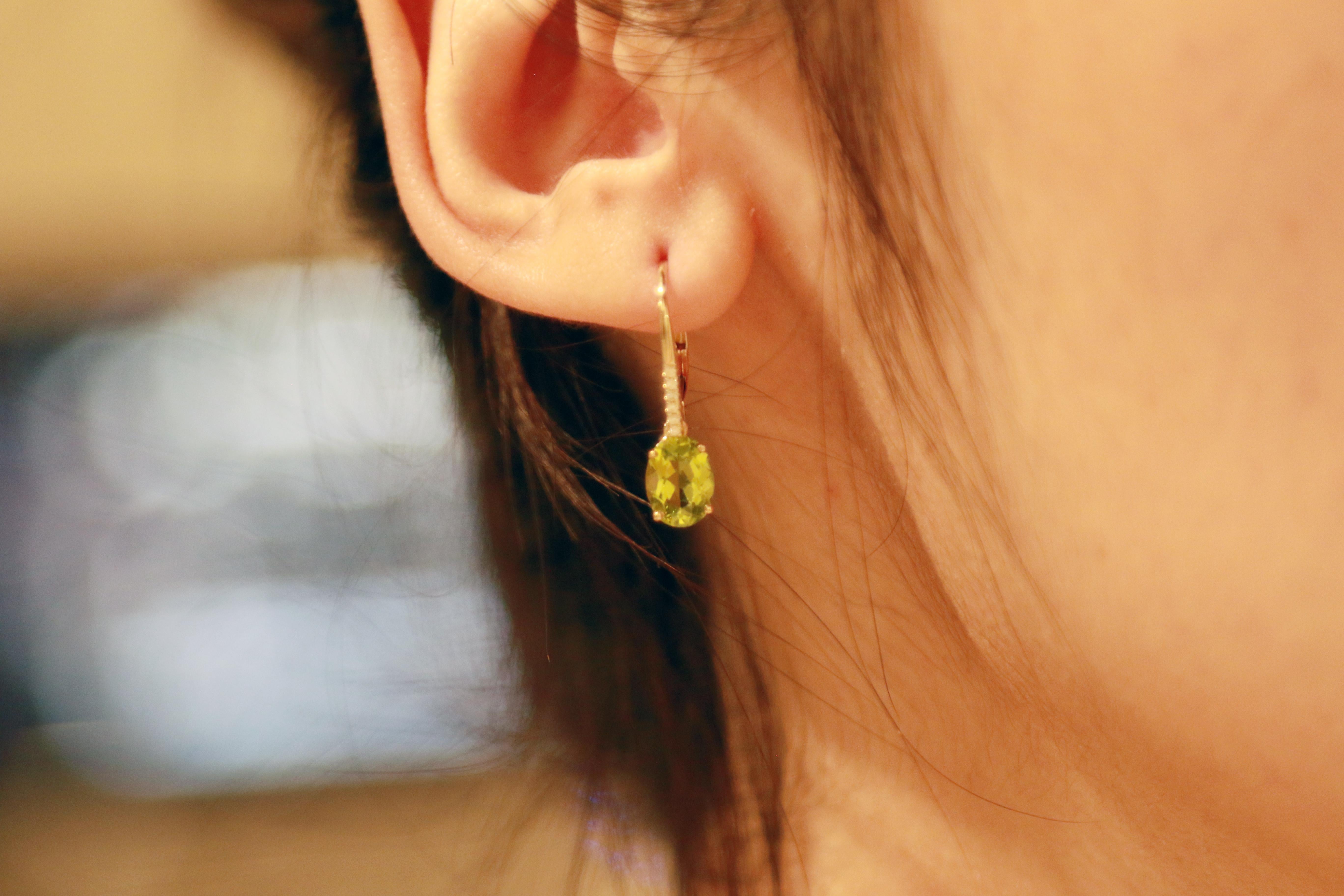 Decorate yourself in elegance with this Earring is crafted from 10K Yellow Gold by The Gin & Grace Earring. This Earring is made up of 5X7 Oval-Cut prong setting Genuine Peridot (2 pcs) 2.91 Carat and Round-Cut prong setting Diamond (12 pcs) 0.06