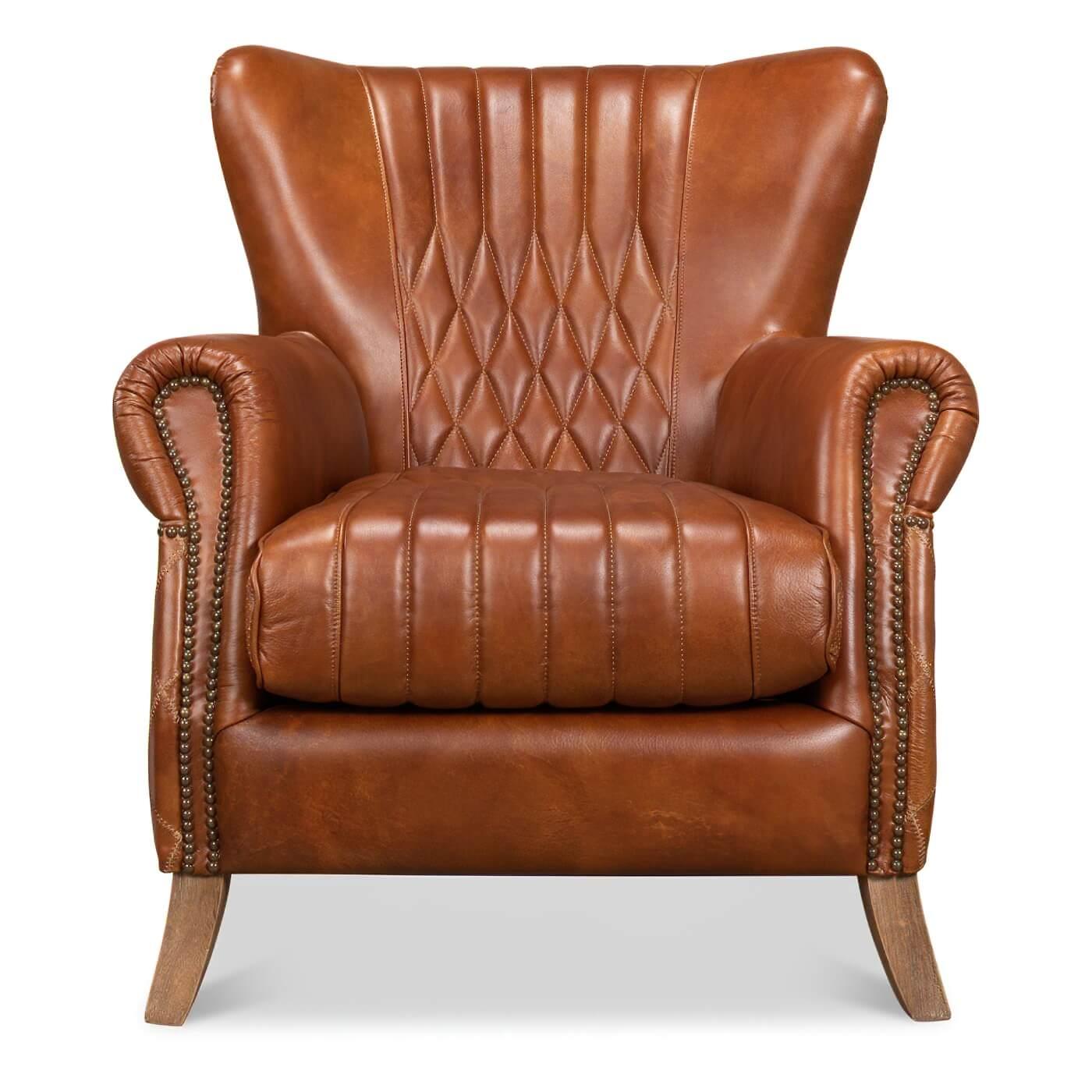 Fauteuil classique en cuir matelassé avec garnitures en têtes de clous. Cette chaise classique est revêtue de notre cuir brun de Cuba et présente un motif matelassé sur son dossier et ses côtés intérieurs et extérieurs. Ses accoudoirs roulés et son