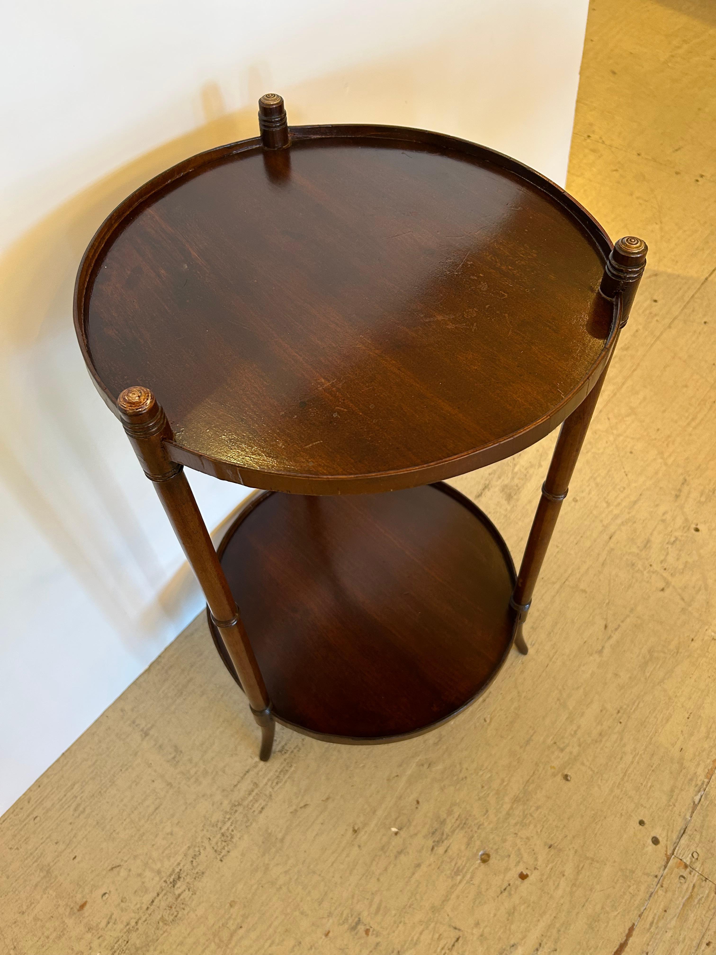 Classically elegant Regency two tier round end table having tapered thin lovely legs.