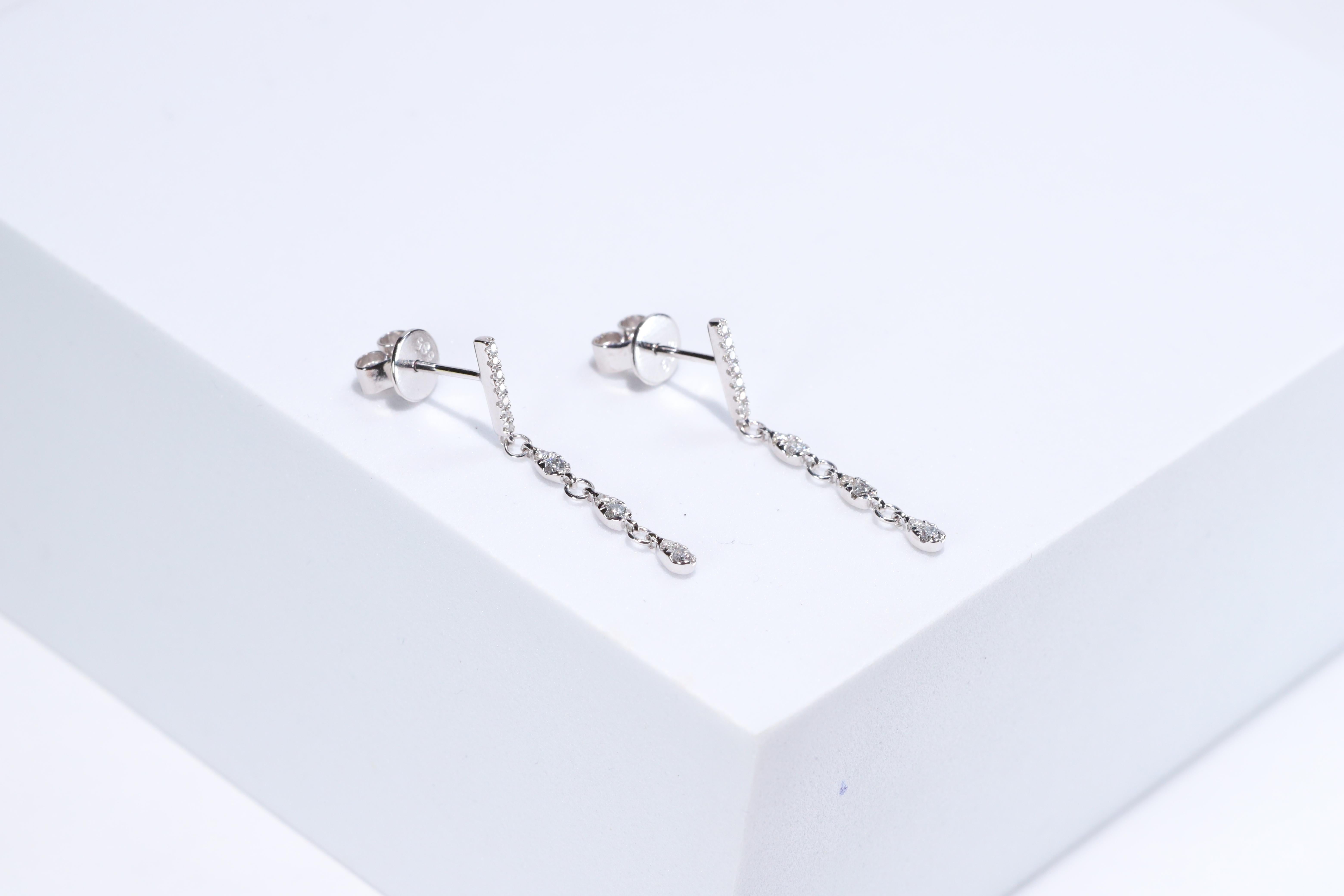 Each of these pretty earrings from Gin & Grace features a with white diamonds. These earrings are made of rich 14-karat White gold with a high polish. Style: Dangle, Diamonds: 26 pcs Diamond cut: Round Diamond weight: 0.20 carat Color: G-H Clarity: