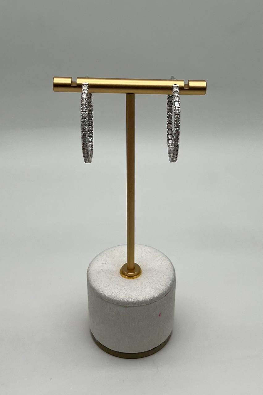 A sophisticated pair of large classic hoop earrings. Each earring features a sleek hoop design, encrusted with shimmering round-cut Diamonds(2.26 ct), offering a refined elegance. 14K White Gold.