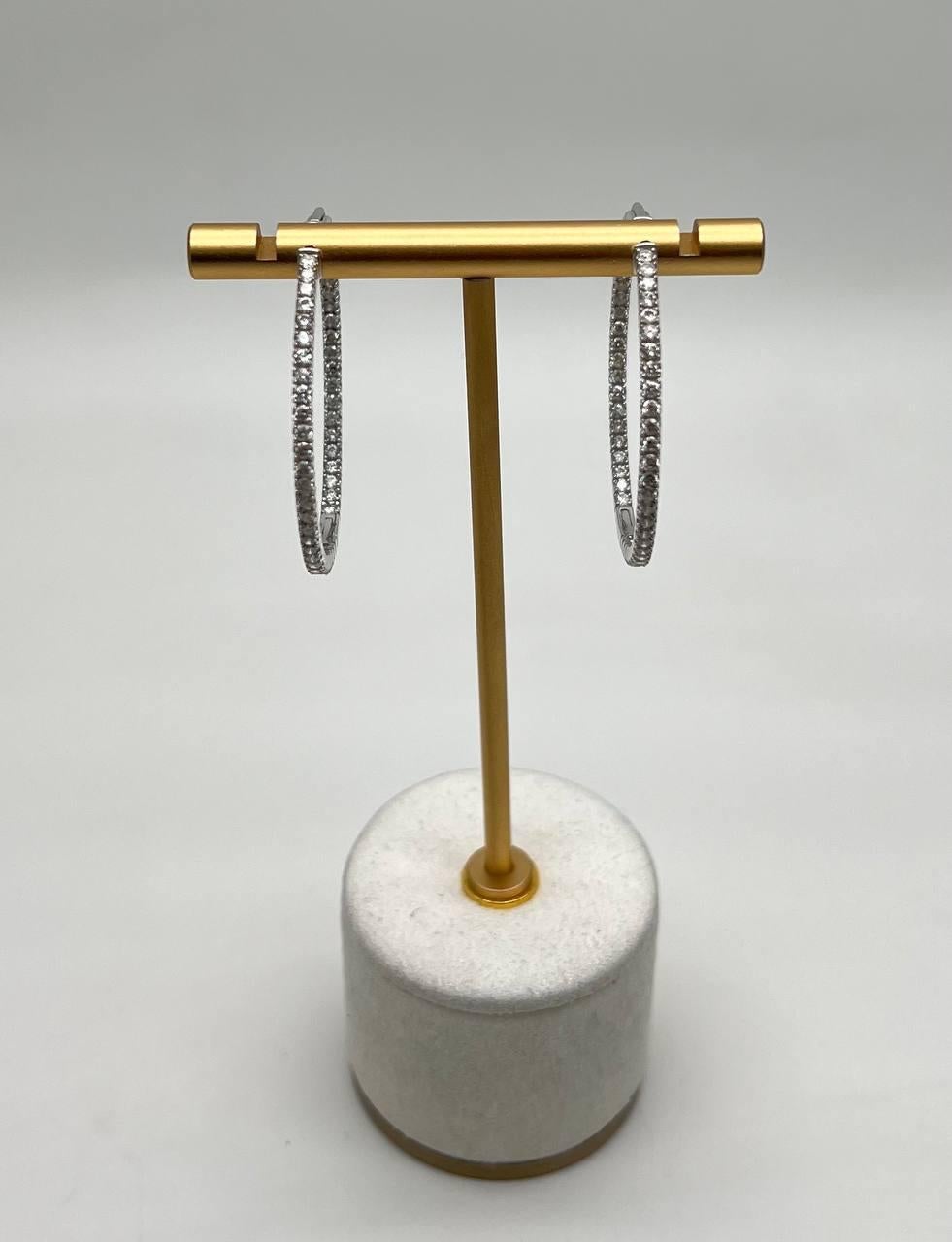 Discover the elegance of these diamond hoop earrings. Featuring 3.25 carats of brilliant-cut white diamonds, these earrings radiate sophistication. Set in 14k white gold, they offer a sleek and modern appeal.
