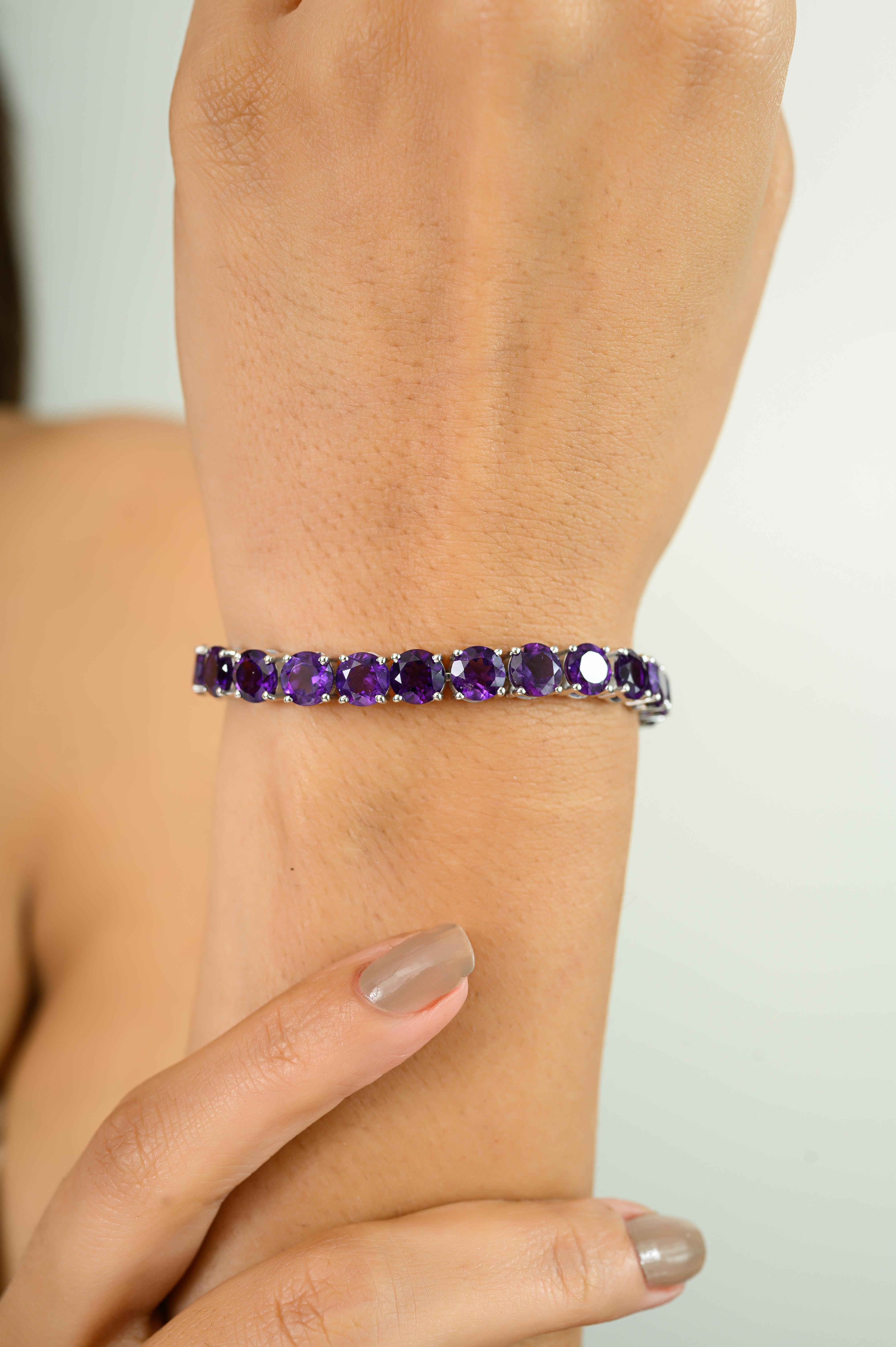 This Round Faceted Amethyst Classic Tennis Bracelet stunning amethyst tennis bracelet, expertly crafted in 925 sterling silver. This elegant piece features a continuous line of rich purple, round-cut amethysts with a total stone weight of 22.42