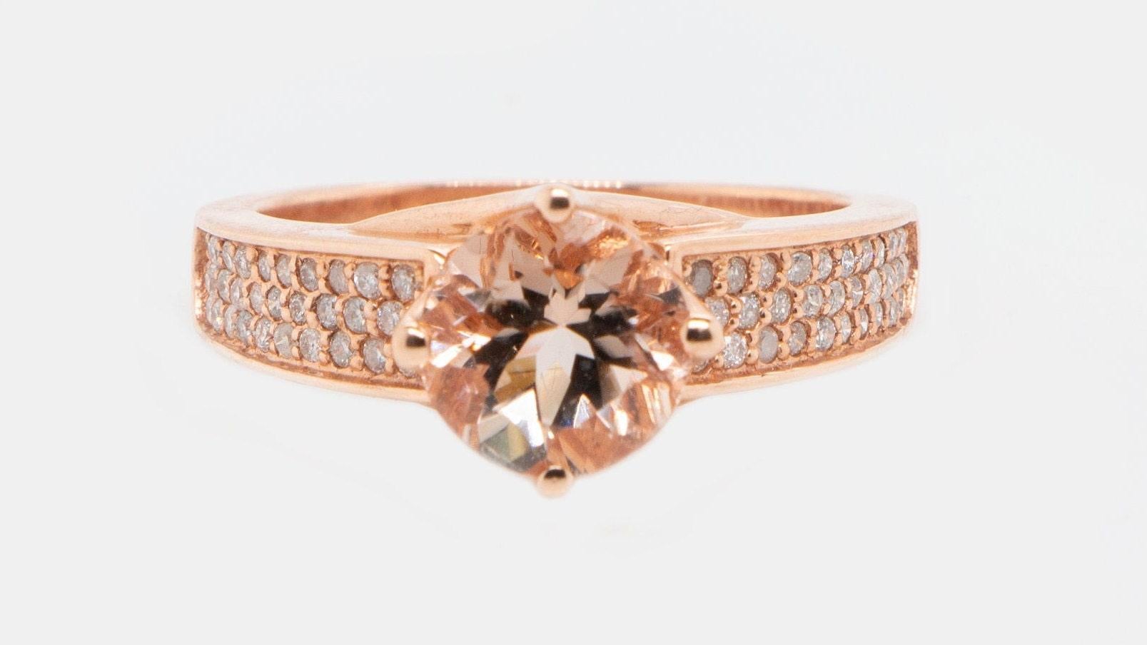 This is a gorgeous natural 1.77 carat round morganite and diamond ring set in solid 14k rose gold. The natural 8MM round morganite has an excellent peachy pink color (AAA quality gems) and is surrounded by a thick halo of round cut white diamonds.