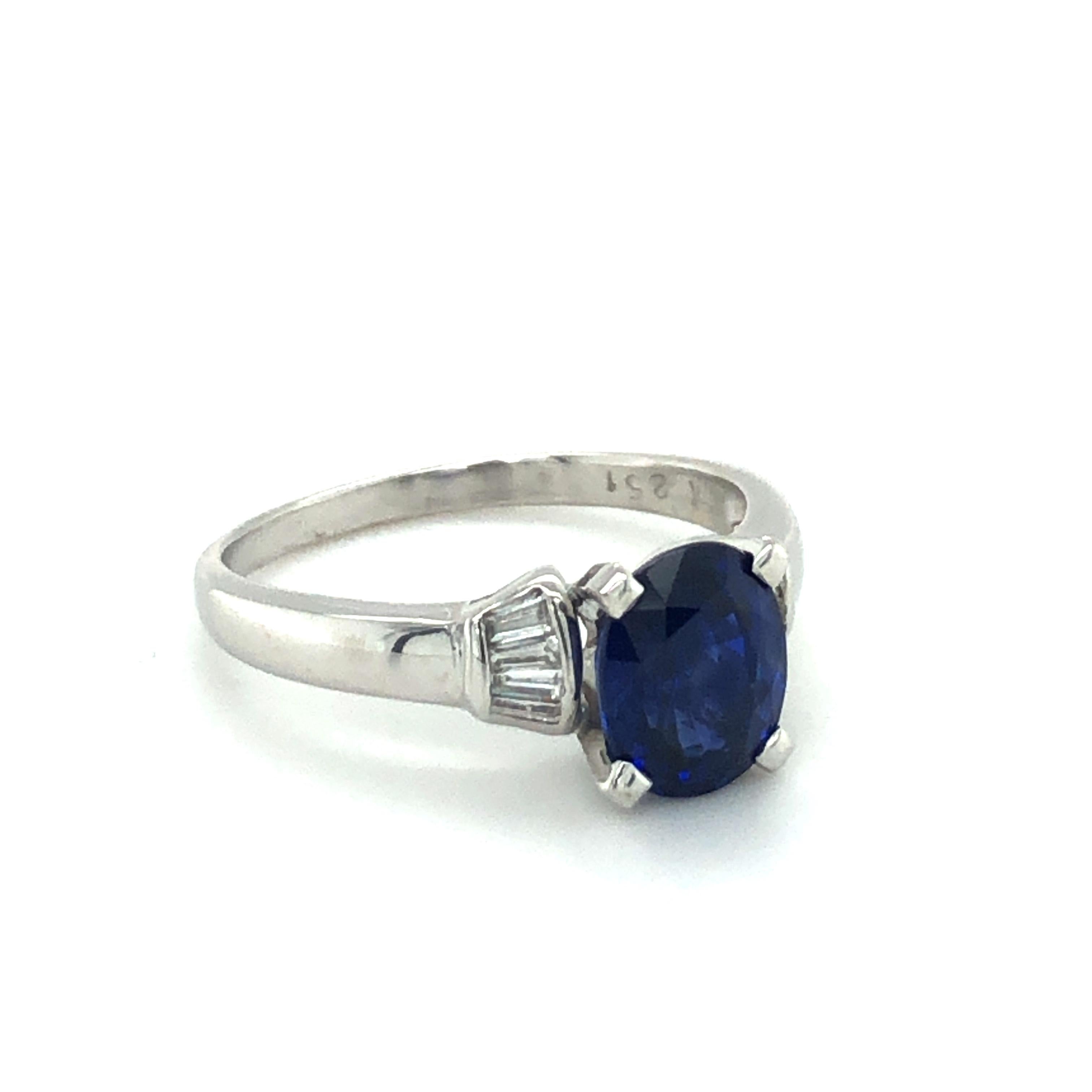 This beautiful and timeless ring in 18 karat white gold is set with a lively coloured cushion-shaped sapphire of approximately 2.51 carats. Accented by 8 tapered baguette-shaped diamonds of G/H colour and vs clarity, total weight approximately 0.22