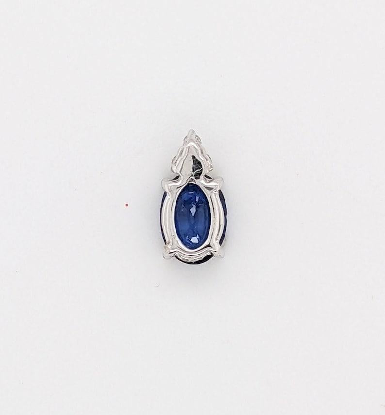 Questo bellissimo ciondolo presenta una gemma ovale di zaffiro da 0,91 carati con una triade di diamanti naturali estratti dalla terra sulla parte superiore della gemma, il tutto incastonato in oro massiccio 14K. Questo ciondolo può essere un bel