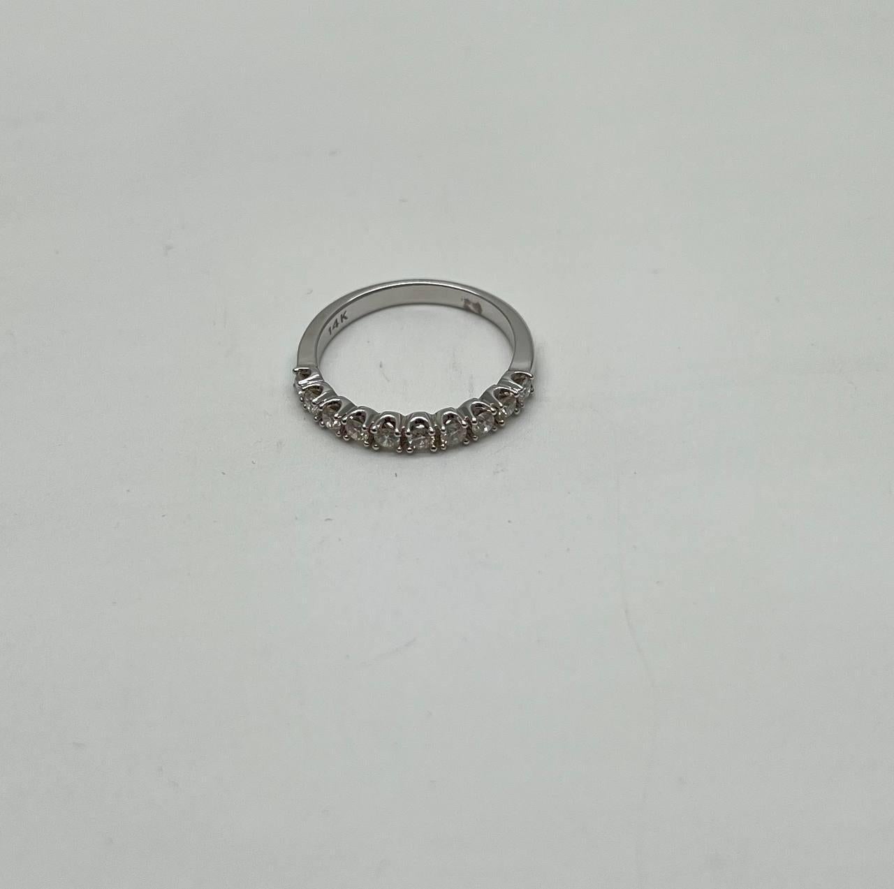 A refined and elegant ring featuring 0.42 carats of brilliant-cut white diamonds. The diamonds are set in a sleek band, showcasing their brilliance and clarity. Crafted in 14k white gold, this exquisite piece.
