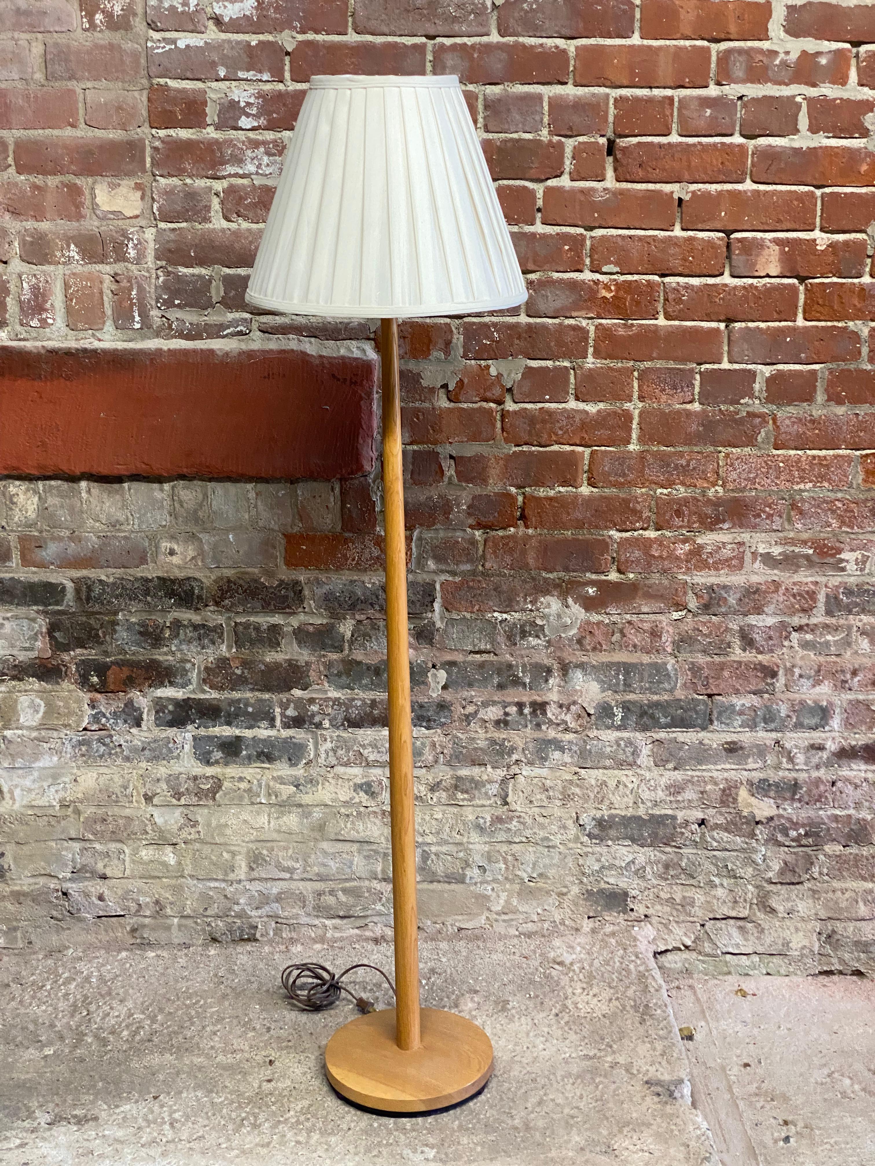 The classic Scandinavian Modern minimalist floor lamp. Made of sturdy solid oak with a footed iron base that obviously gives the floor lamp some weight at the bottom. Tapered round shaft that is slightly wider at the bottom. The lamp retains its