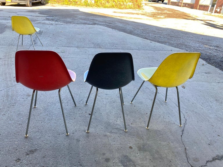 Classic set of 4 Charles Eames fiberglass scoop /side chairs 1950s Herman Miller. Nice early group dated 1958-1959, 2 lemon yellow, 1 crimson orange, 1 elephant hide grey, all 4 in nice original condition, retain original gel coat, exposed fibers,